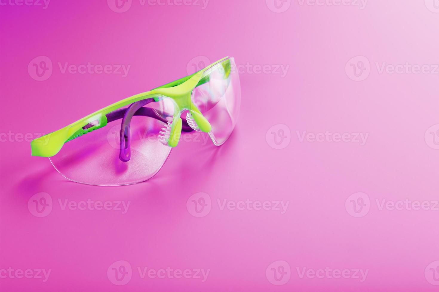 óculos de segurança de policarbonato transparente em um fundo rosa foto