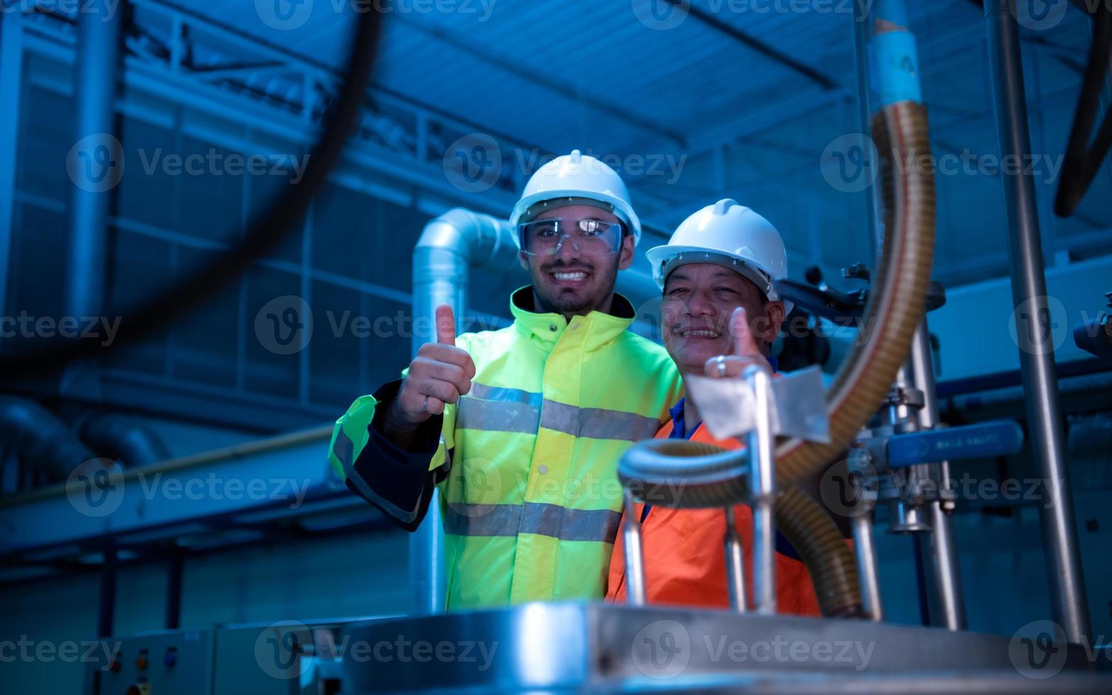 engenheiro-chefe da planta mecânica inspecionando a manutenção da máquina com os técnicos da fábrica foto