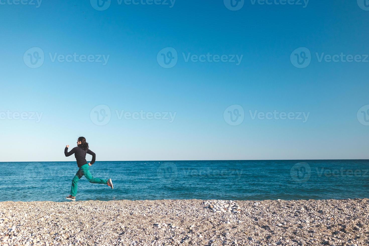 uma garota em uma corrida matinal na praia foto