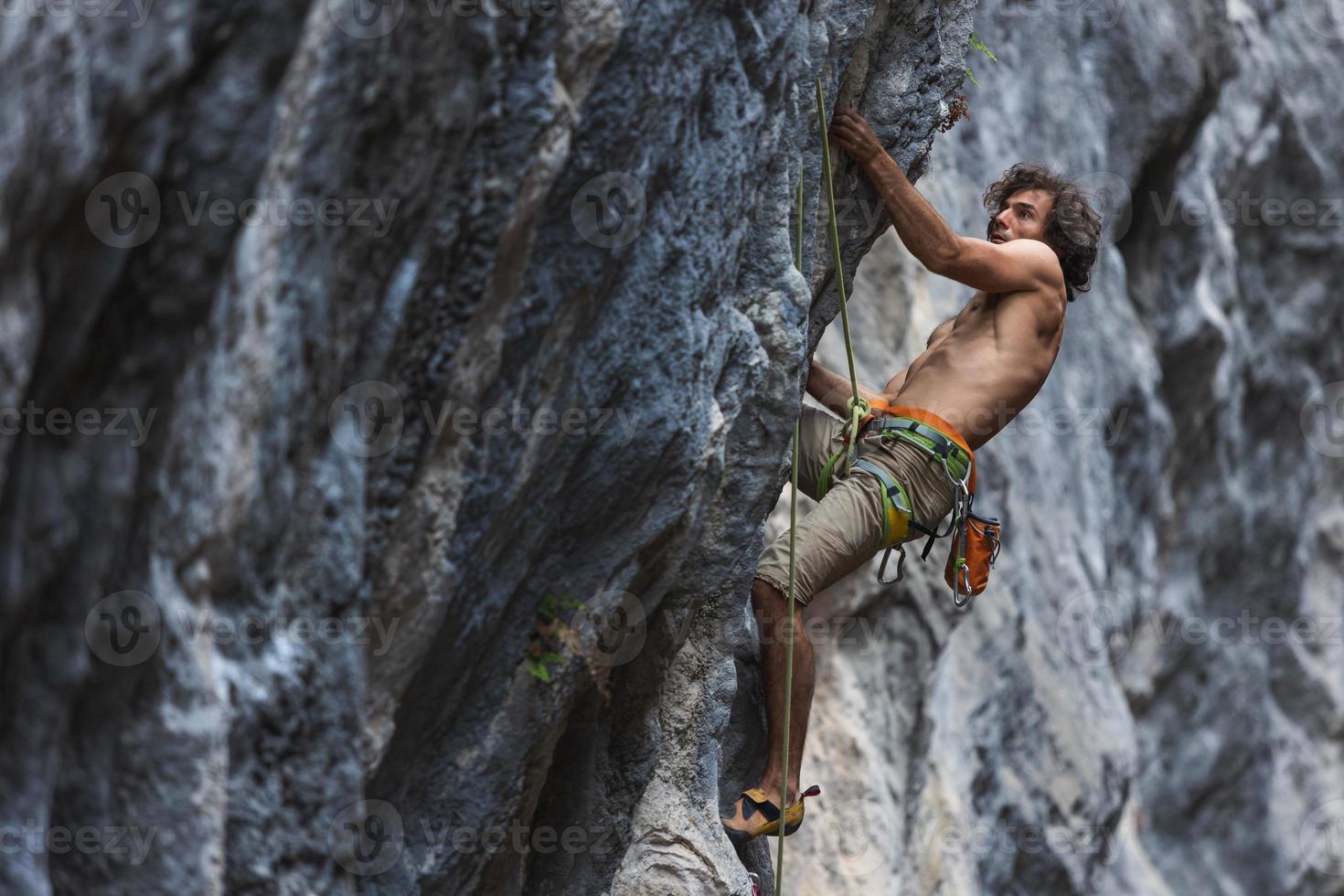 homem forte escalando uma rocha. foto