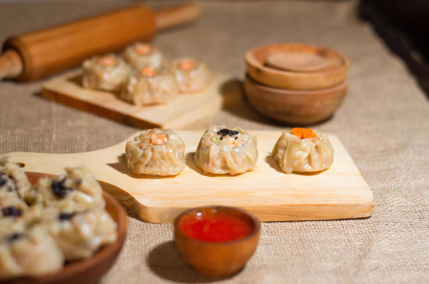 dimsum cozinhado chinês ou dim sum, na placa de madeira, cozinha tradicional foto