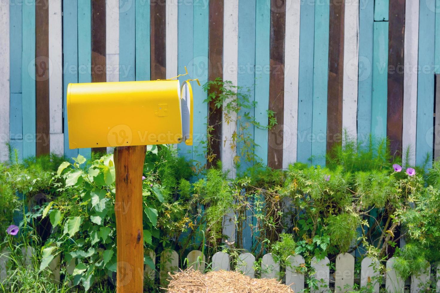 caixa de correio vintage amarela com parede de madeira no jardim foto