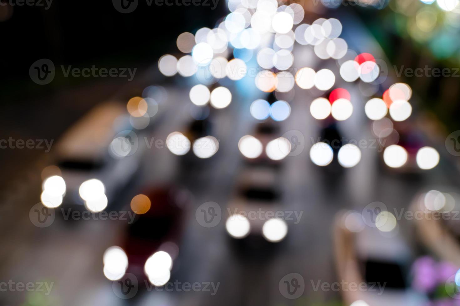 faróis desfocados de luz na cidade de rua foto
