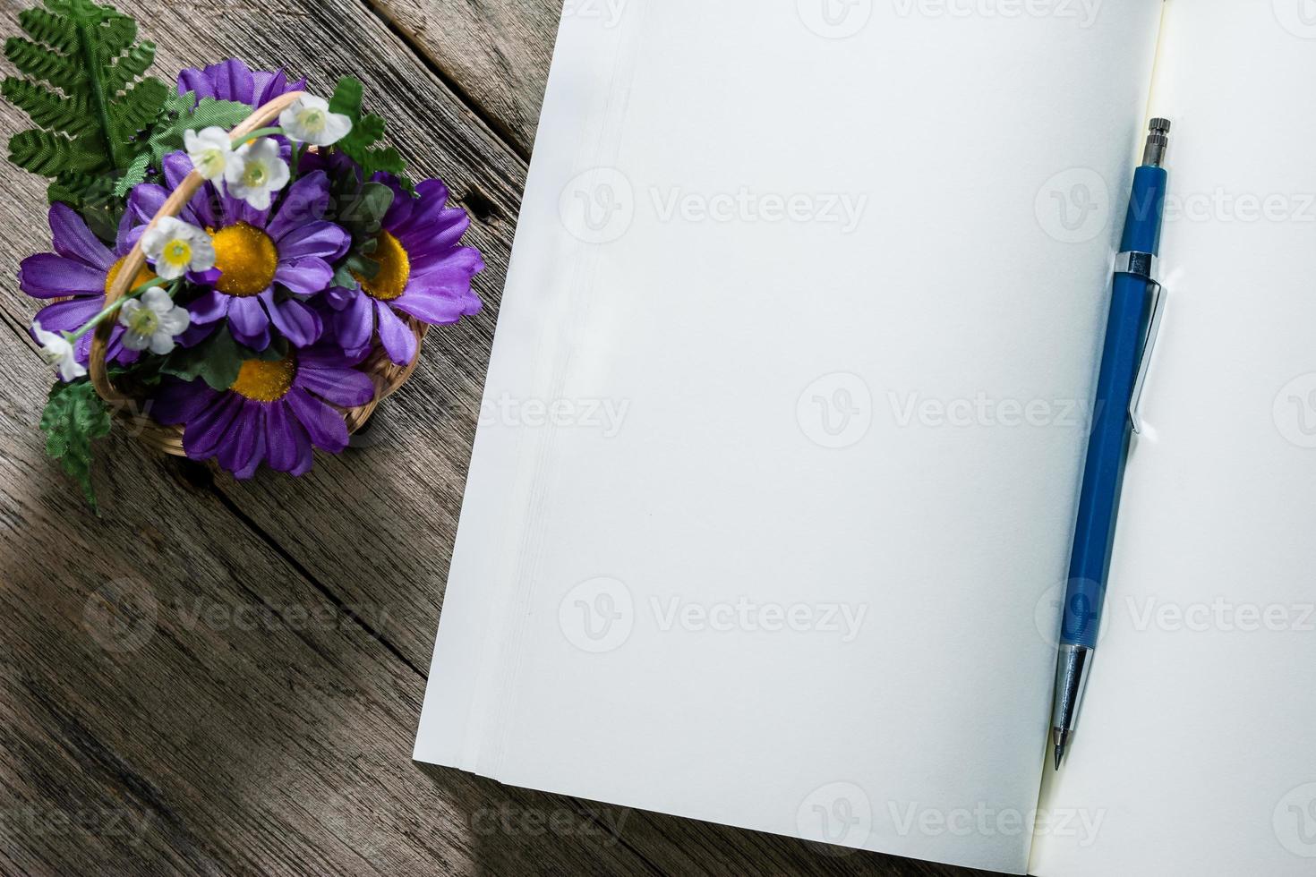 caderno aberto com lápis tipo embreagem sobre fundo de madeira foto