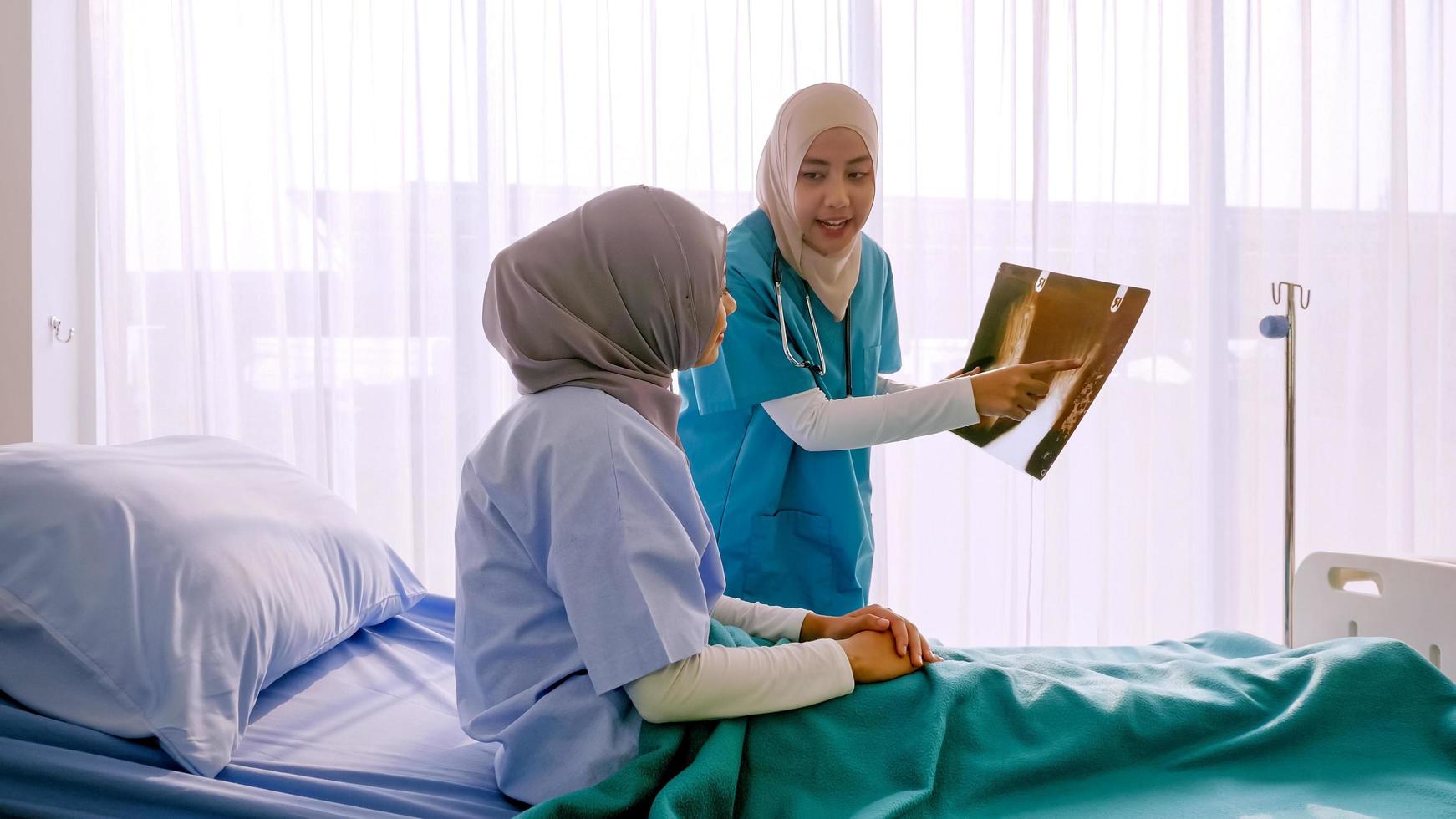 médica muçulmana analisando a doença ao paciente no quarto do hospital. foto