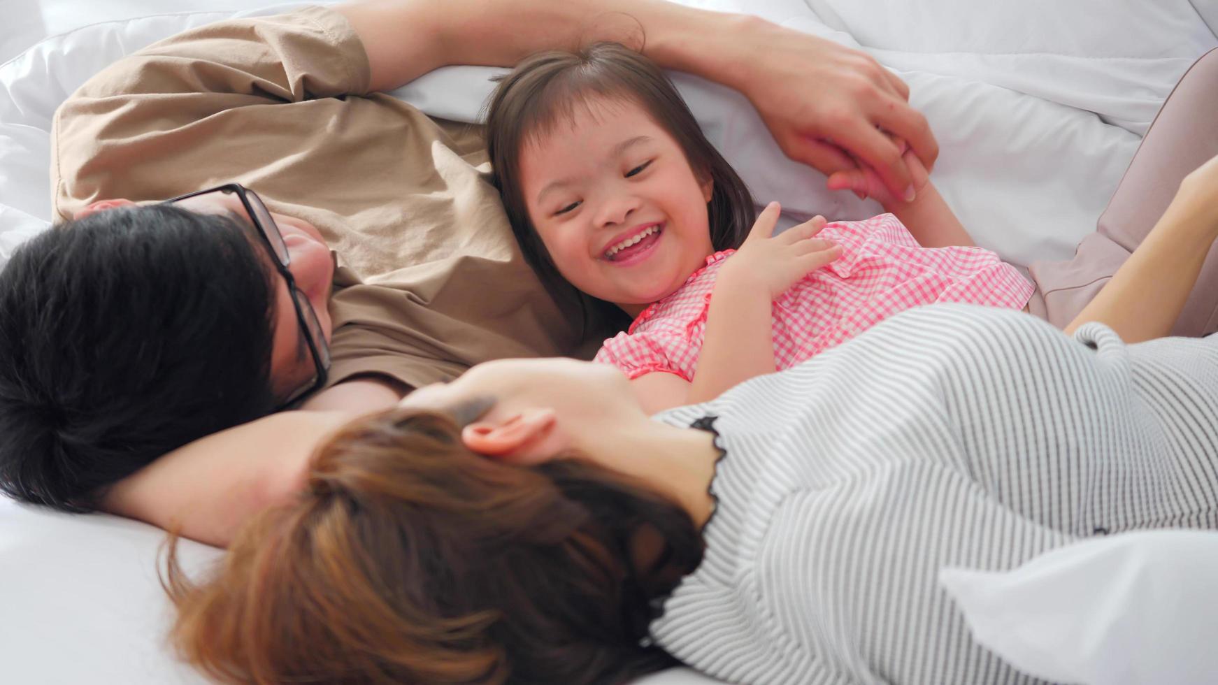 família feliz com mãe, pai e filha com deficiência passando tempo juntos no quarto. foto