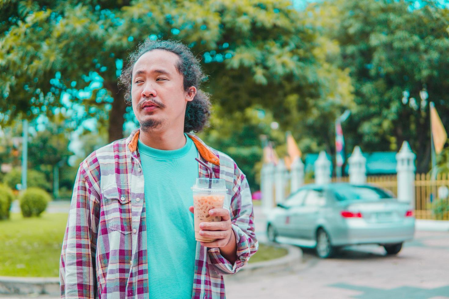 homem asiático tomando café com paisagens naturais foto