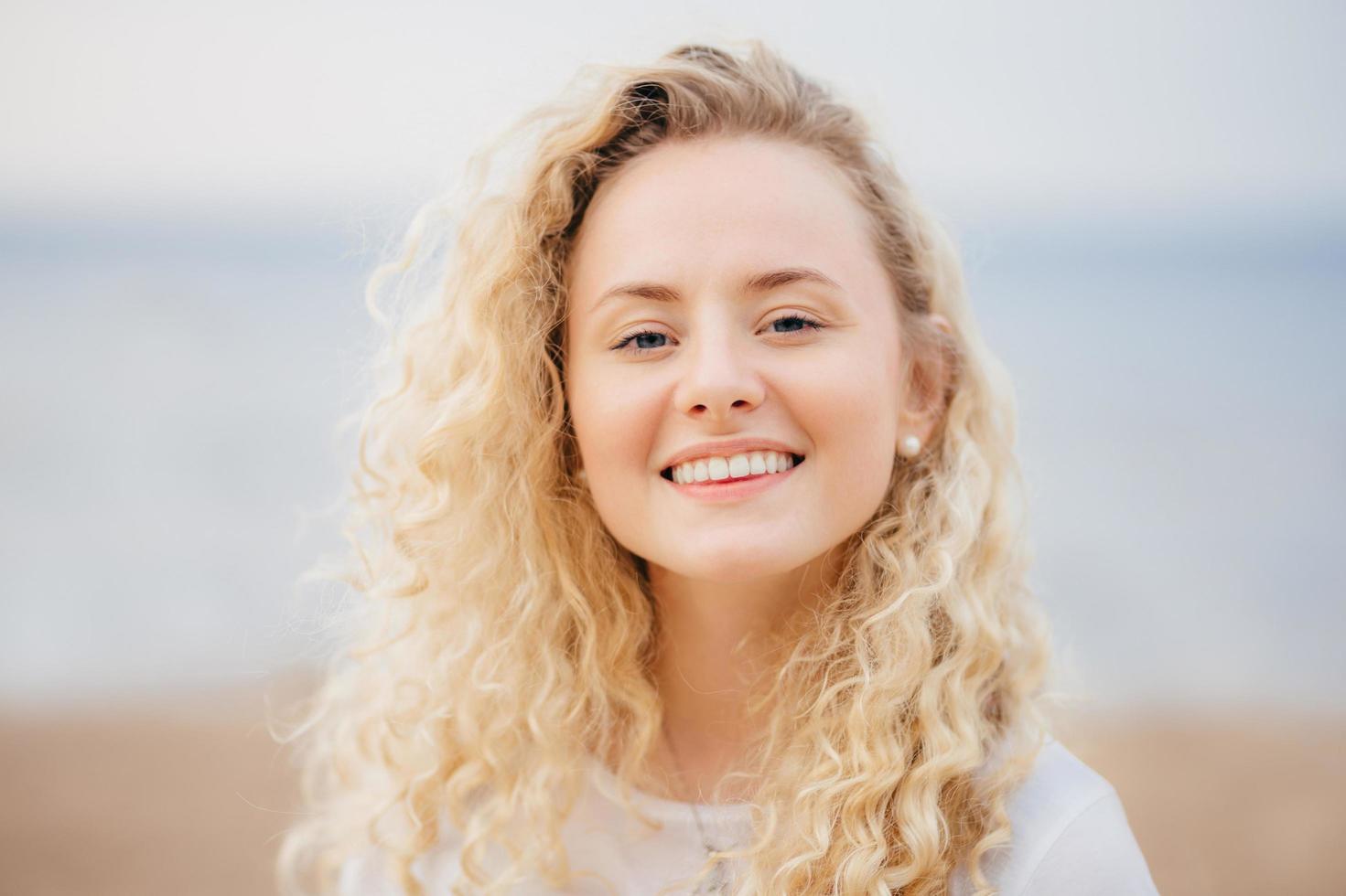 tiro na cabeça de mulher bonita com sorriso amigável, tem pele saudável, estar de bom humor após descanso inesquecível no país resort com namorado, tem aparência atraente. pessoas, beleza, conceito de estilo de vida foto