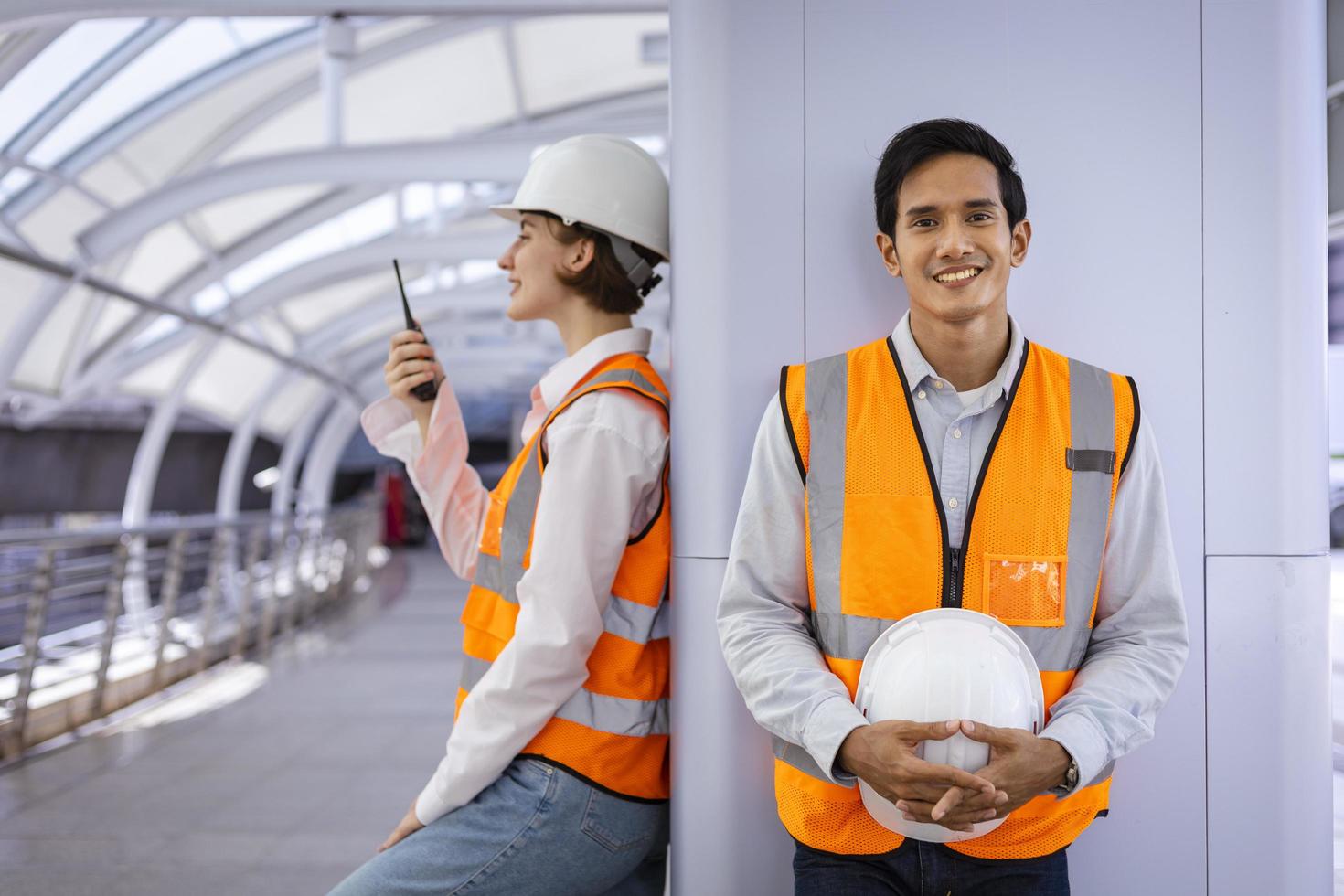 equipe de engenheiro de diversidade está usando walkie talkie enquanto inspeciona o projeto de construção para arquitetura moderna e conceito de desenvolvimento imobiliário foto