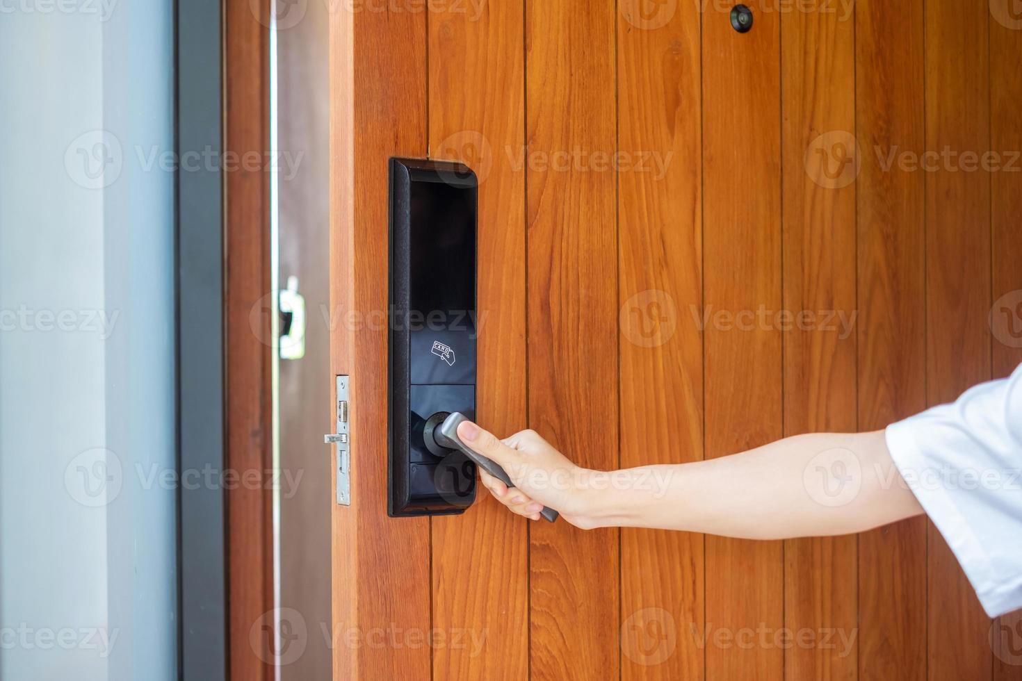 homem segurando a maçaneta da fechadura digital inteligente enquanto abre ou fecha a porta. conceitos de tecnologia, elétrica e estilo de vida foto