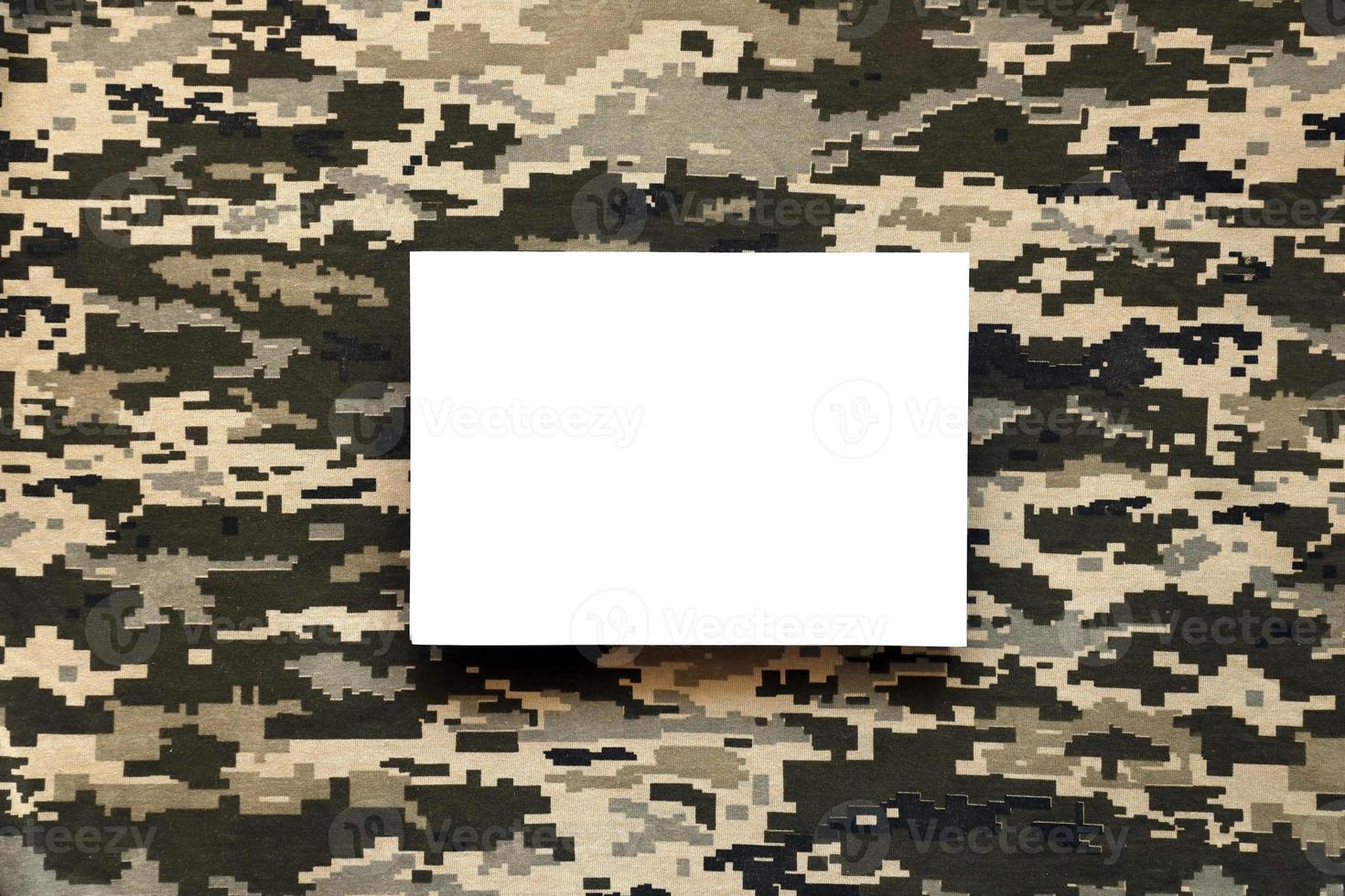 tecido com textura de camuflagem pixelizada militar ucraniana e papel em branco branco. pano com padrão de camuflagem em formas de pixel cinza, marrom e verde. foto