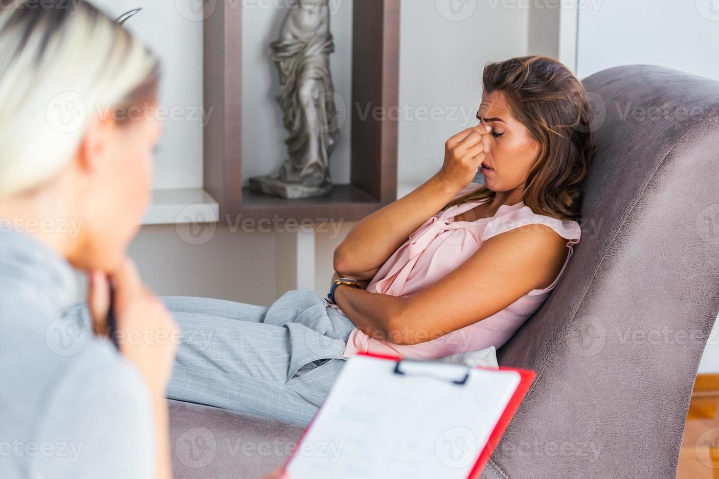 jovem sentada no sofá cobrindo o rosto com as mãos, sentindo-se sem esperança, deprimida ou chorando, visitando psicoterapeuta, descobrindo um diagnóstico ruim ou resultados de exames médicos foto