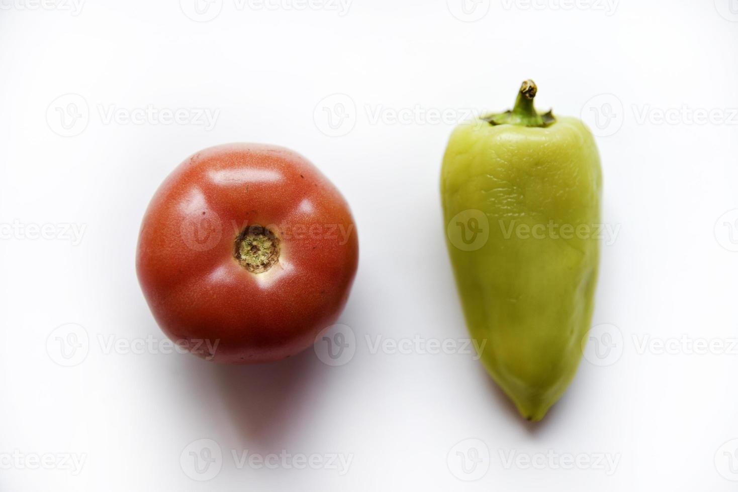 pimentão verde e tomate vermelho em um fundo branco. close-up de legumes. foto