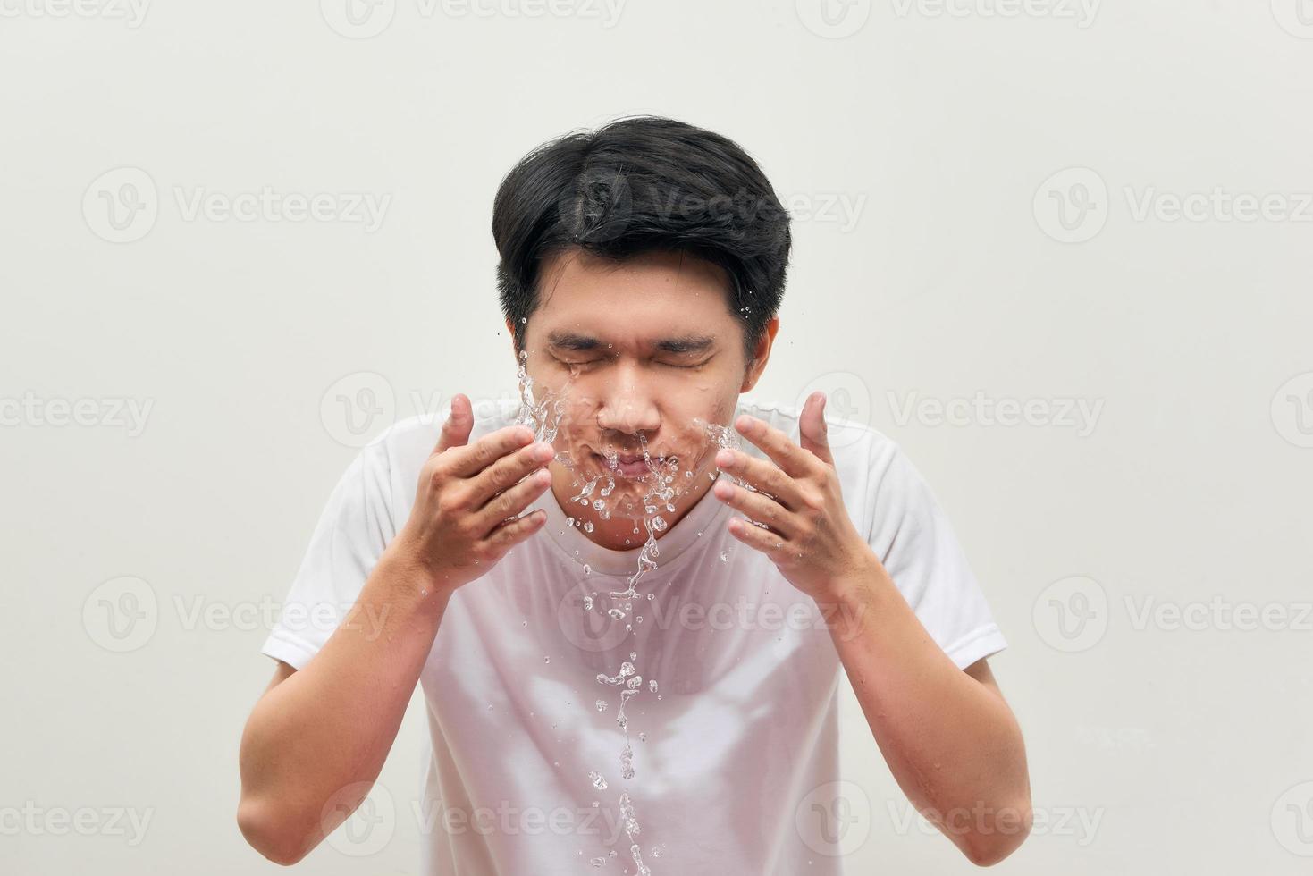 homem bonito está lavando, respingo de água, em um fundo branco foto