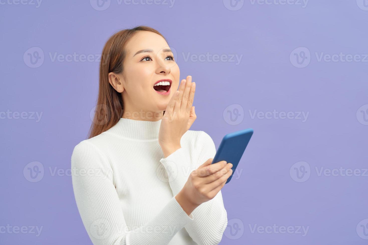 menina asiática feliz usando telefone, comemorando o sucesso, vitória online, jovem animada lendo boas notícias, mostrando sim gesto foto