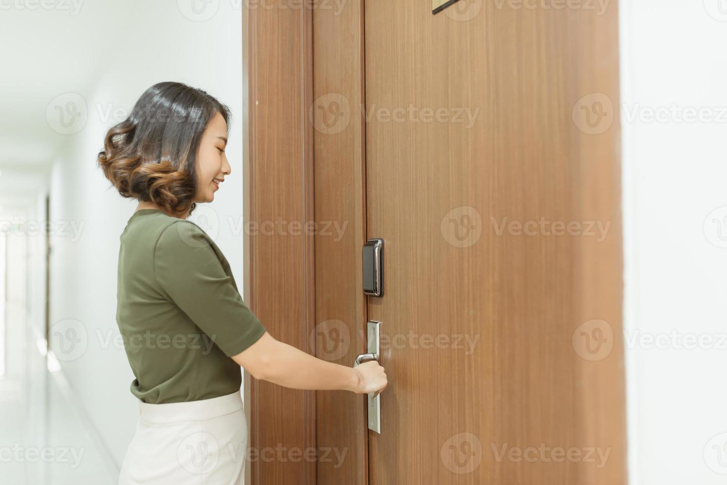mulher abre a porta do apartamento foto