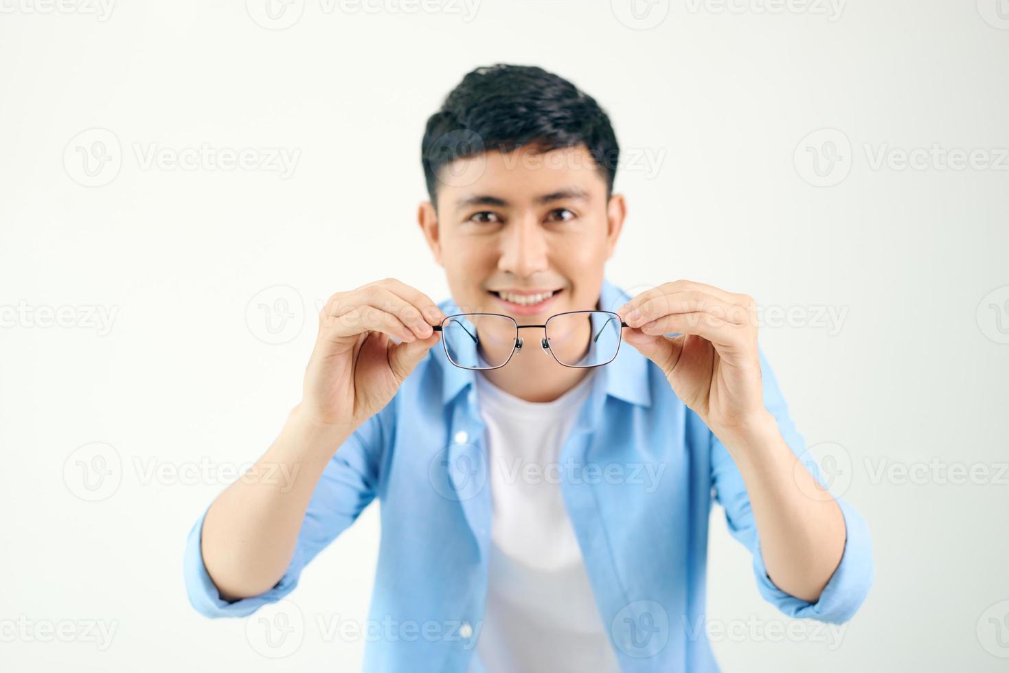 homem bonito segurando óculos diante de seus olhos foto