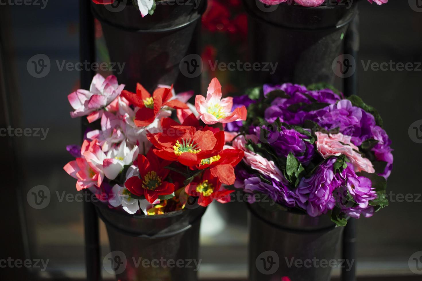 flores são vendidas na rua. flores artificiais para cemitério. detalhes da loja de flores. flores feitas de plástico. foto