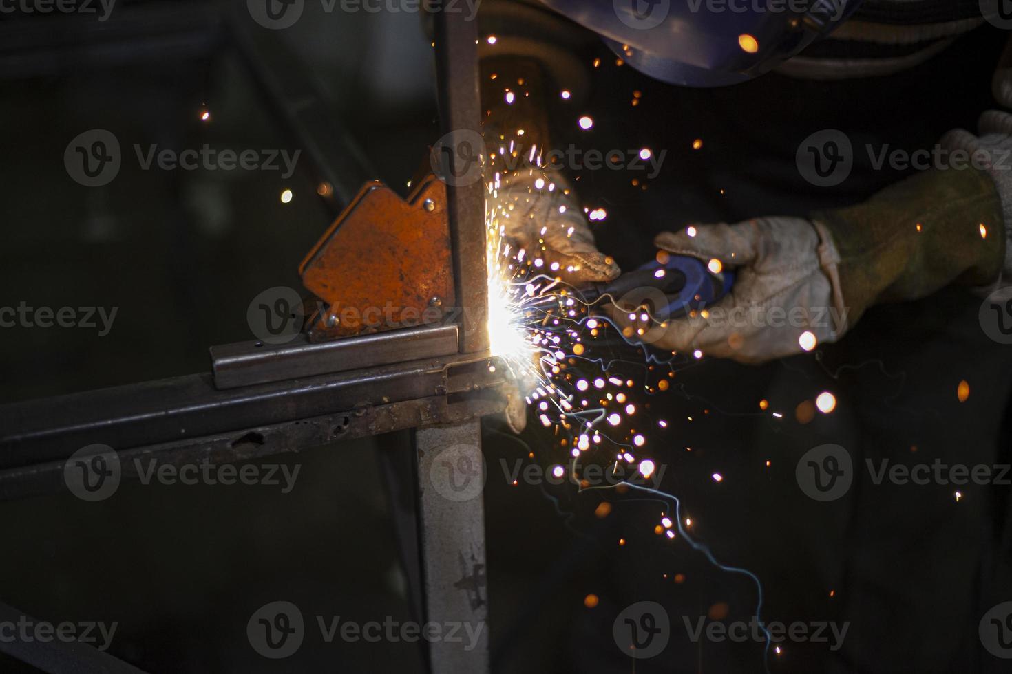 soldagem de metais. fogo da operação da máquina de solda. fabricação de costura de aço. processamento de perfil de aço. faíscas da soldagem. foto