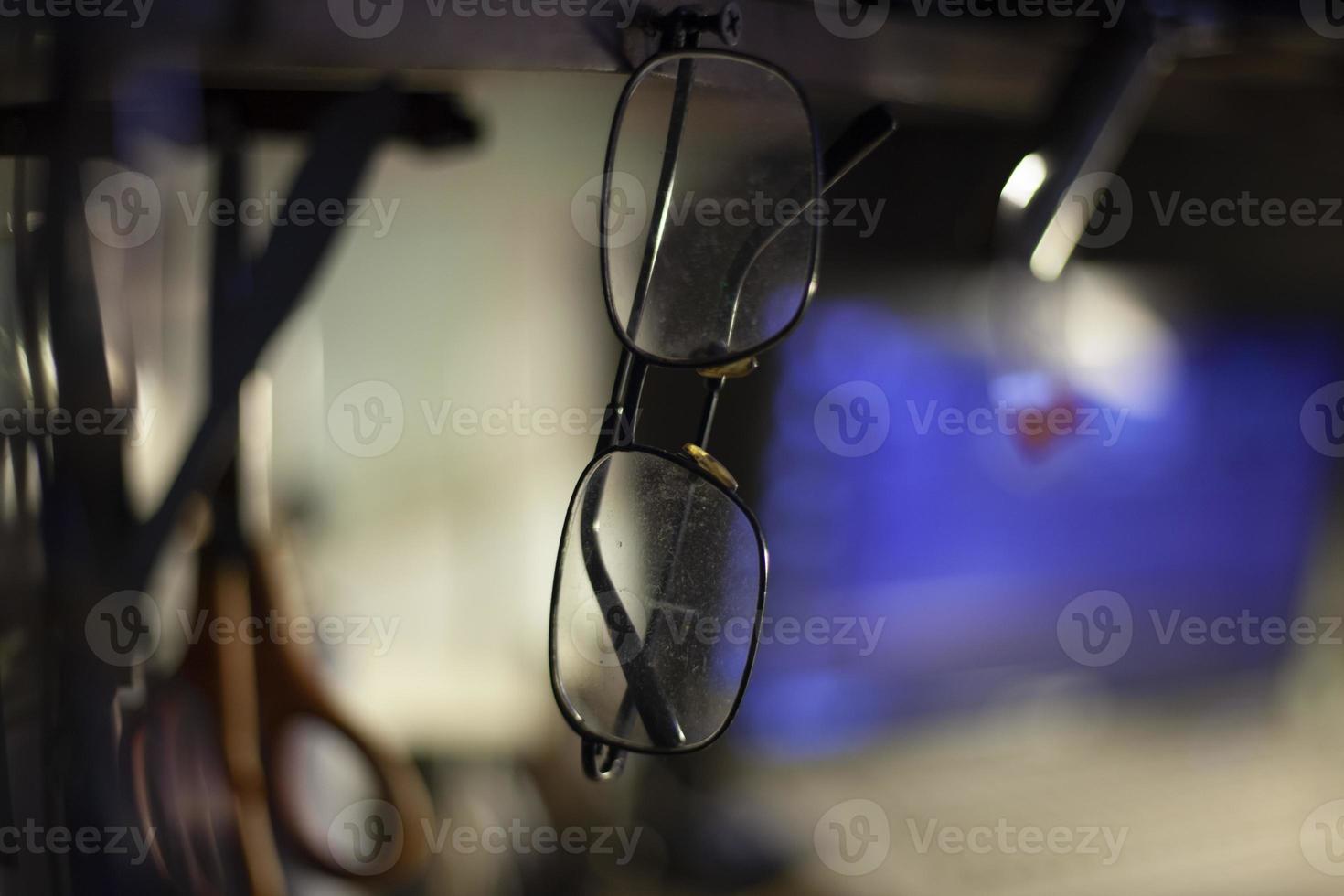 óculos pendurados no lugar. meios para correção da visão. copos feitos de vidro de alta qualidade foram esquecidos no cabide. foto