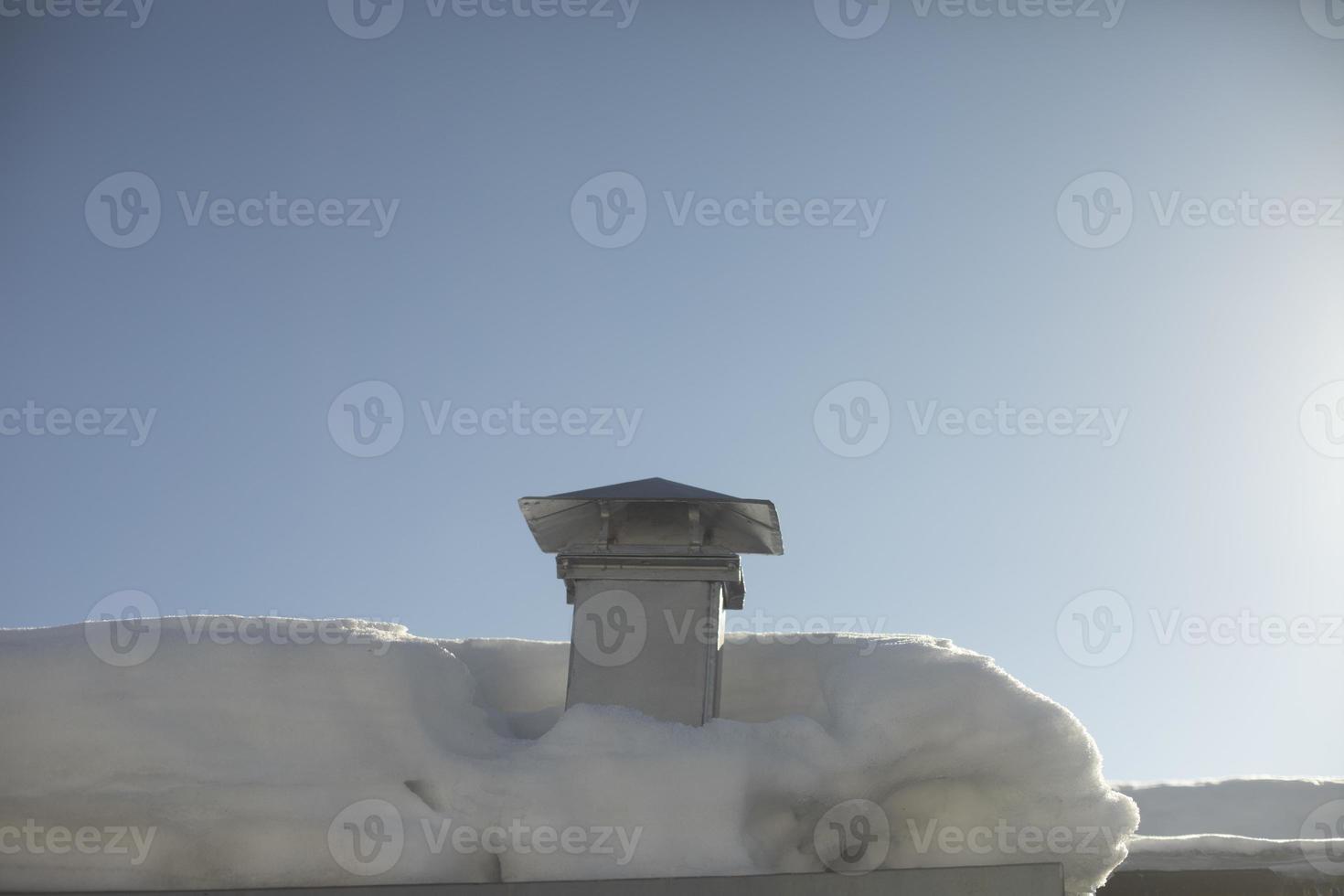 chaminé no telhado no inverno sem fumaça. neve no telhado. detalhes da casa na aldeia. foto