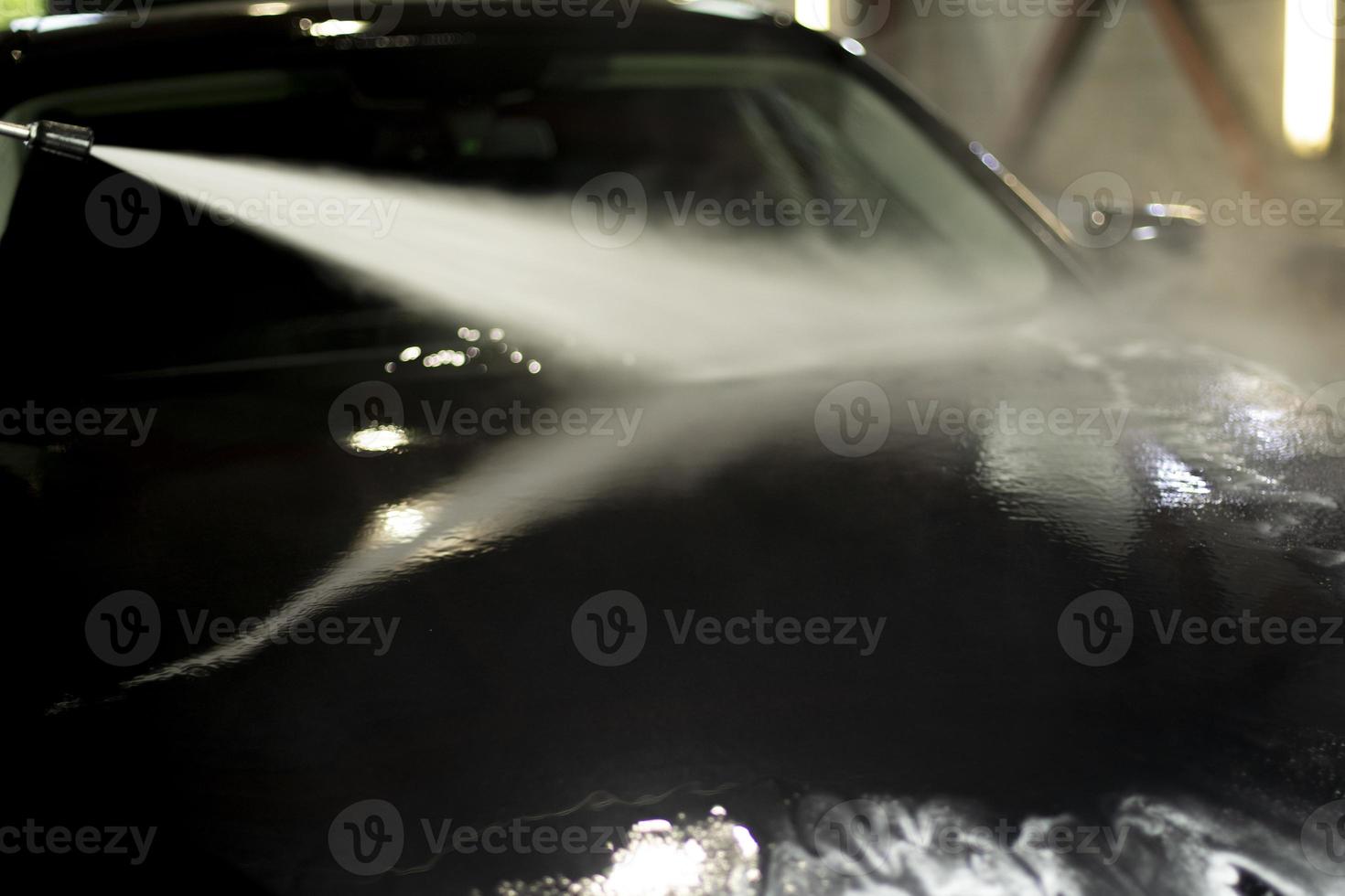 lava-jato. carro preto na lavagem de carros. jato de água quente. foto