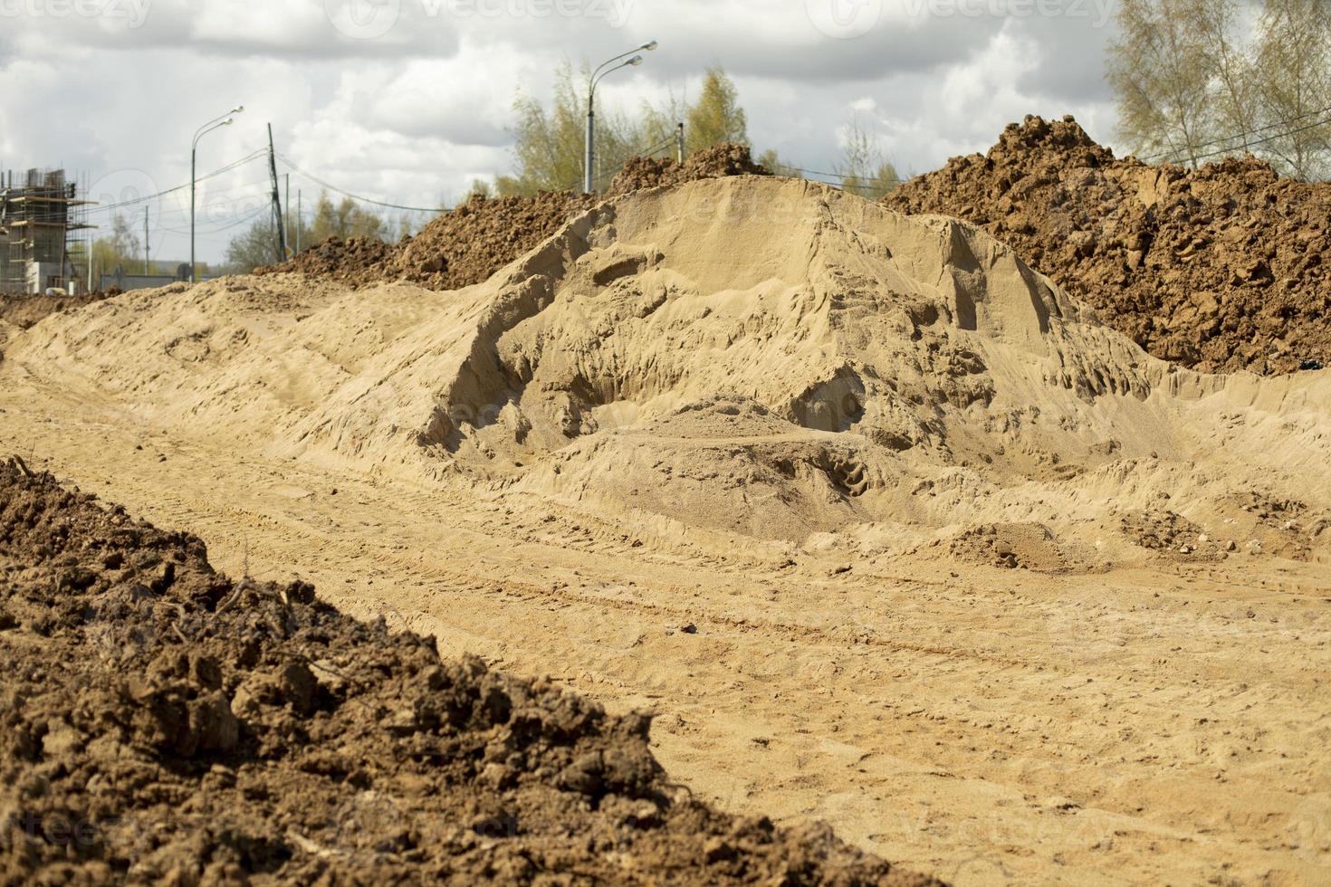 areia de construção. montanha de areia no canteiro de obras. terra escavada. foto