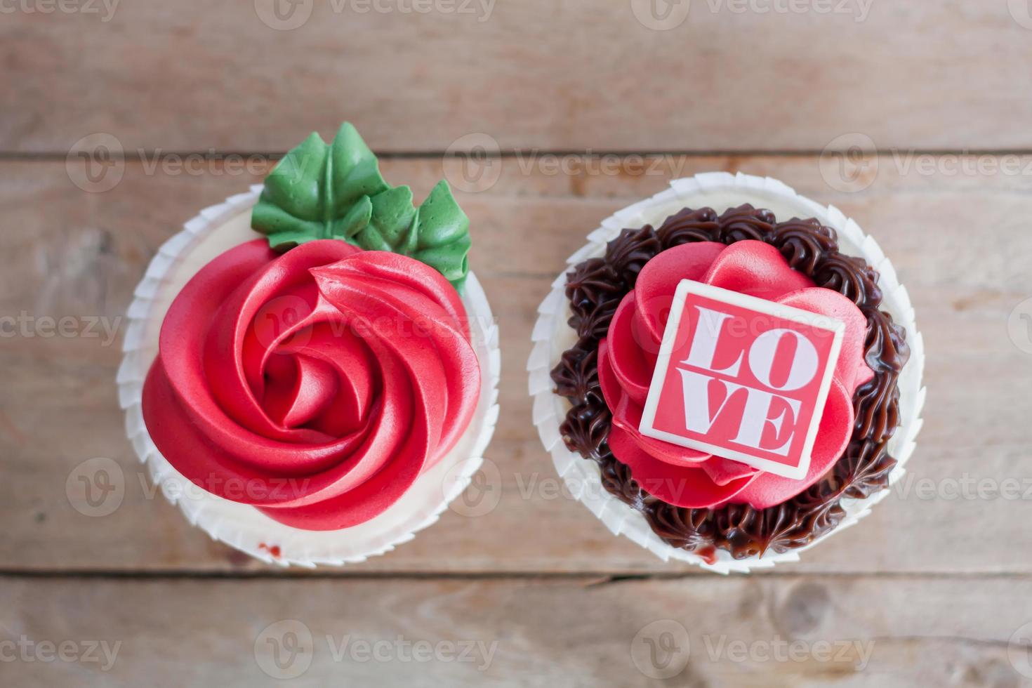 cupcakes de rosas vermelhas na mesa de madeira foto