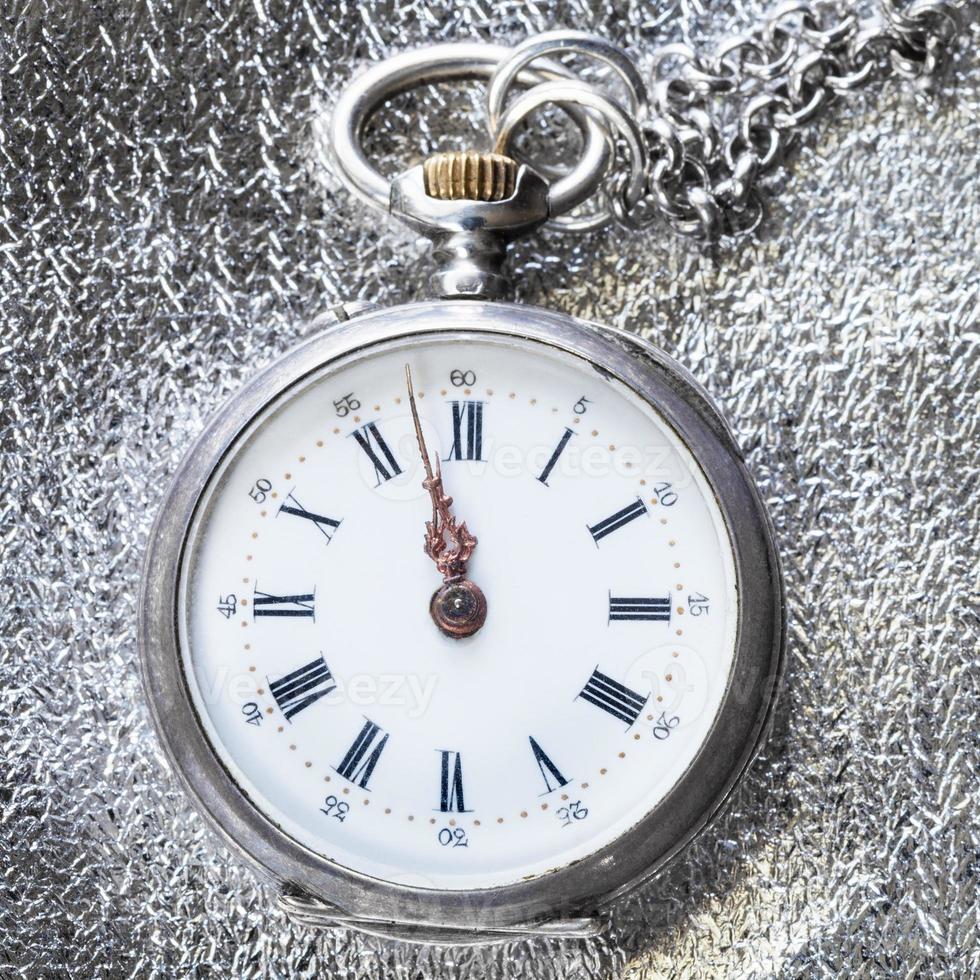 relógio de bolso antigo em pano prateado close-up foto