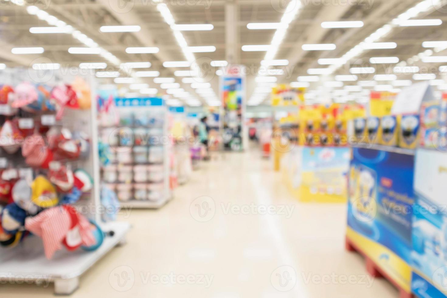 Resumo desfocar o fundo interior do corredor do supermercado com produtos lácteos de fórmula para bebês e roupas nas prateleiras foto