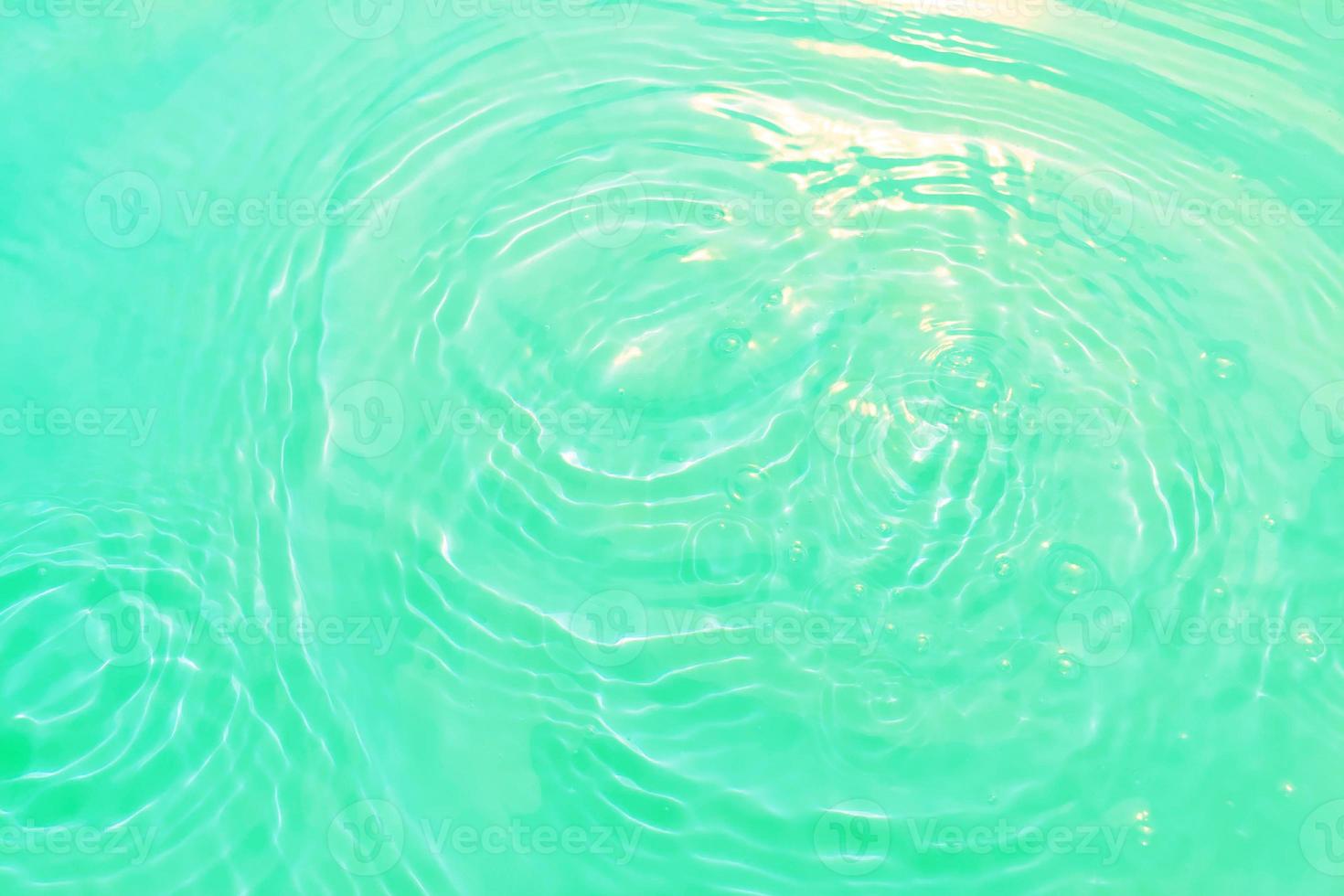 desfocar textura de superfície de água calma transparente de cor azul transparente turva com salpicos e bolha. fundo de natureza abstrata na moda. onda de água na luz solar com espaço de cópia. aquarela azul brilhando. foto