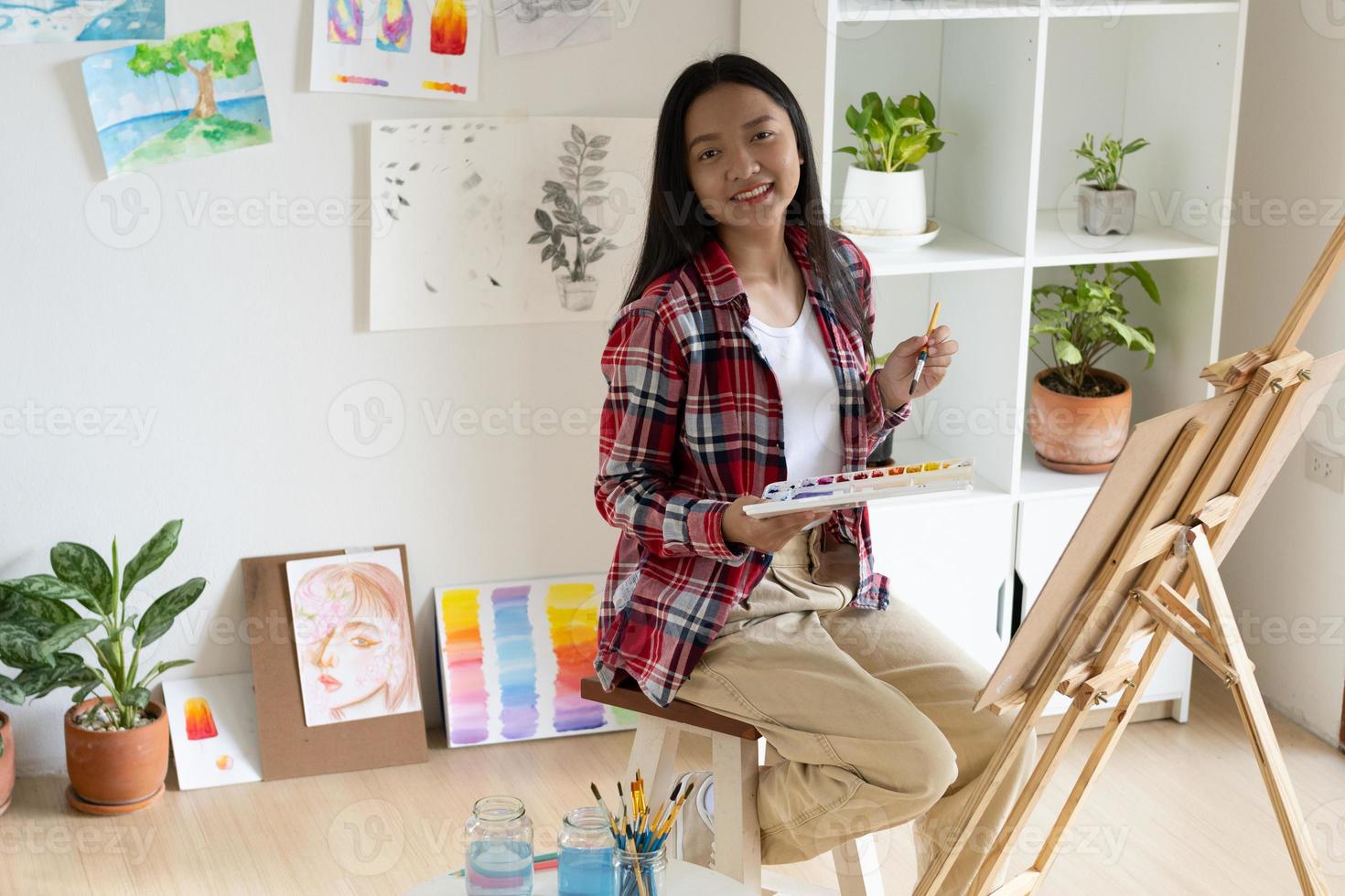 jovem pintando em papel em casa, moldura de madeira, hobby e estudo de arte em casa. foto