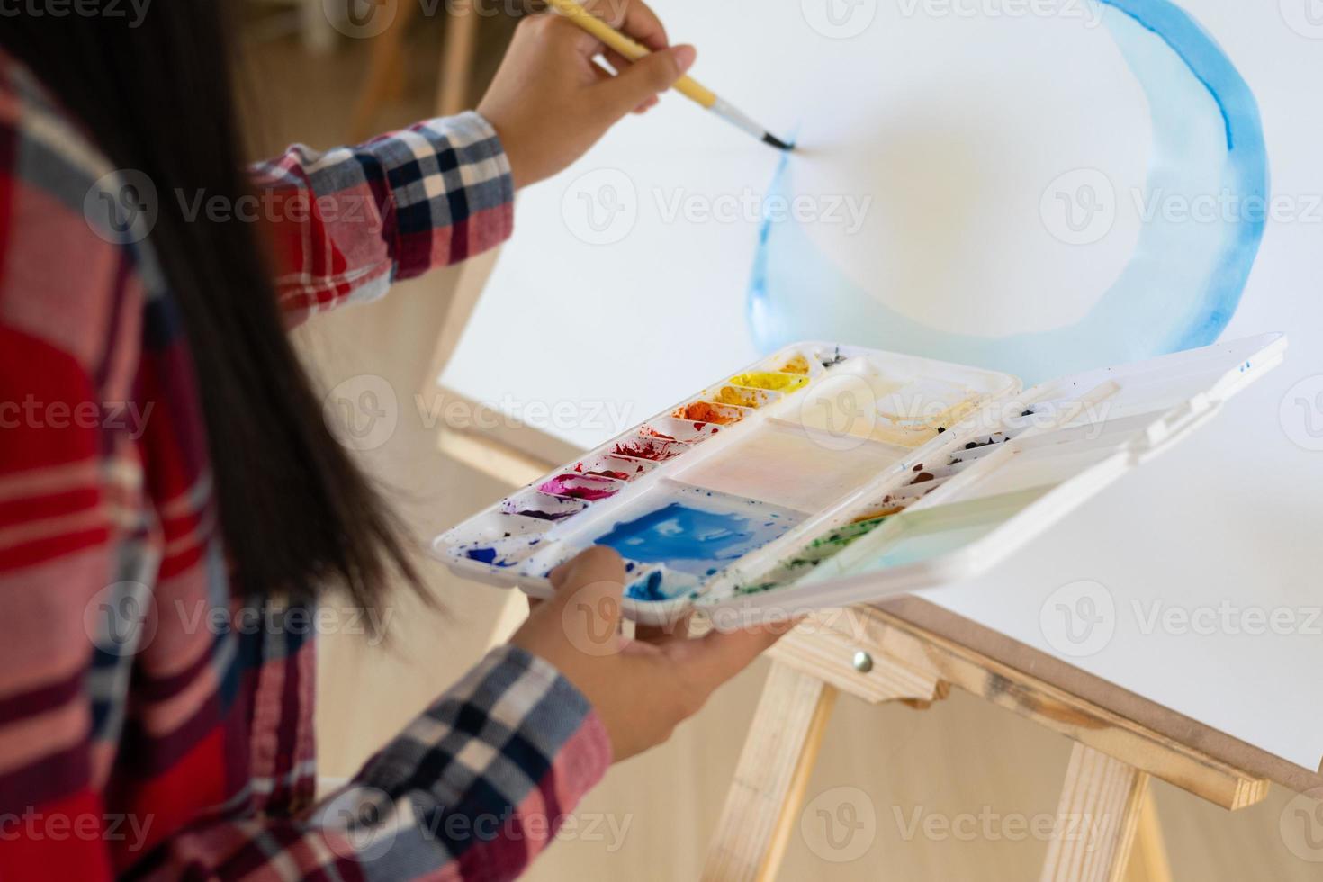 jovem pintando em papel em casa, moldura de madeira, hobby e estudo de arte em casa. foto