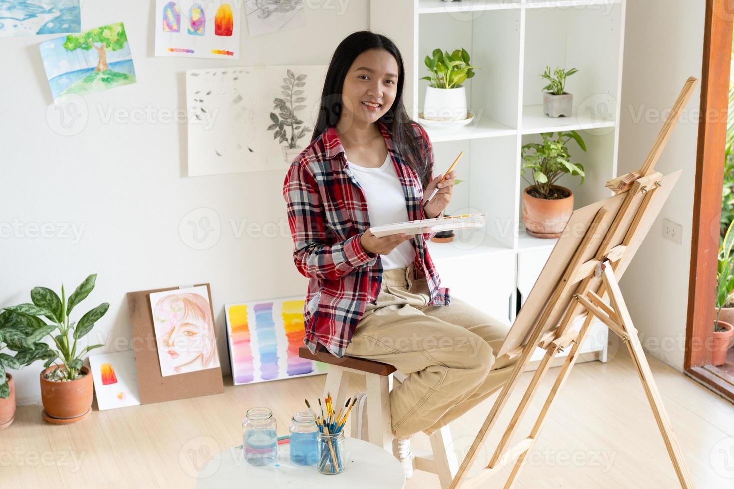 jovem pintando em papel em casa, moldura de madeira, hobby e estudo de arte em casa. foto