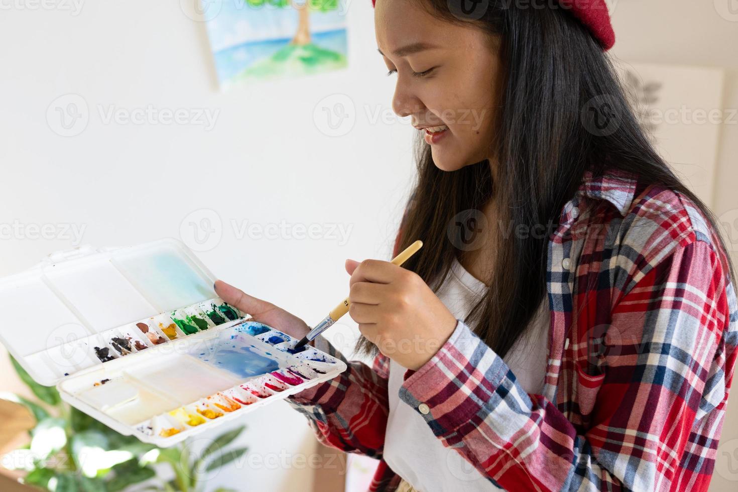 jovem pintando em papel em casa, moldura de madeira, hobby e estudo de arte em casa. foto