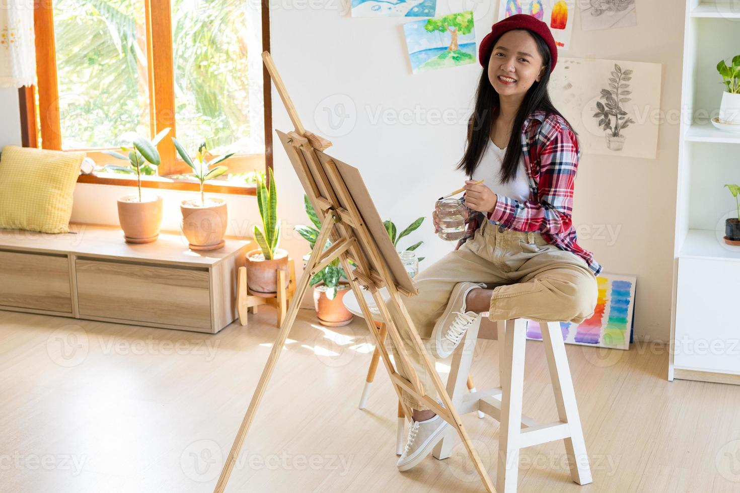 jovem pintando em papel em casa, moldura de madeira, hobby e estudo de arte em casa. foto