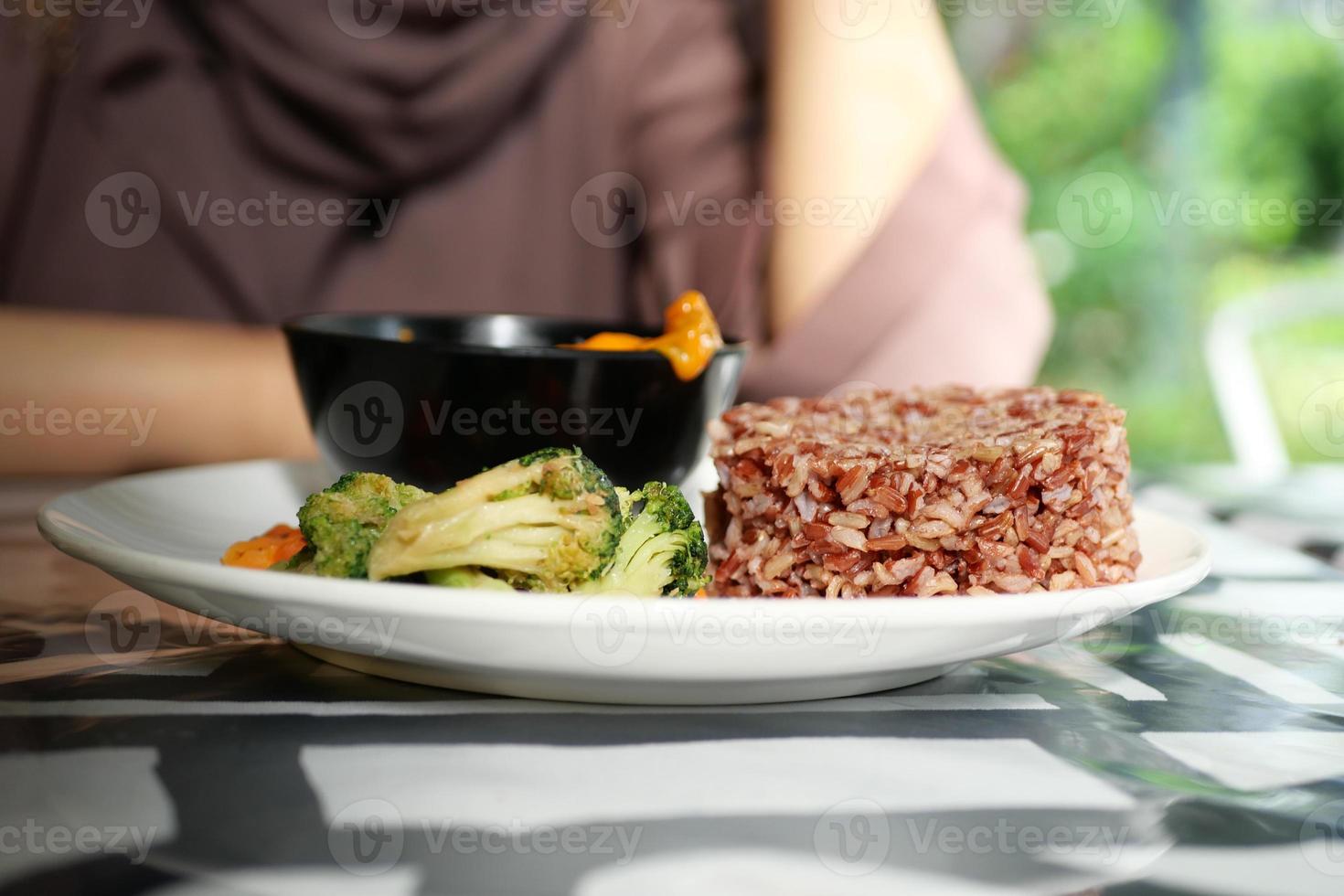 arroz vermelho cozido e legumes em um prato foto