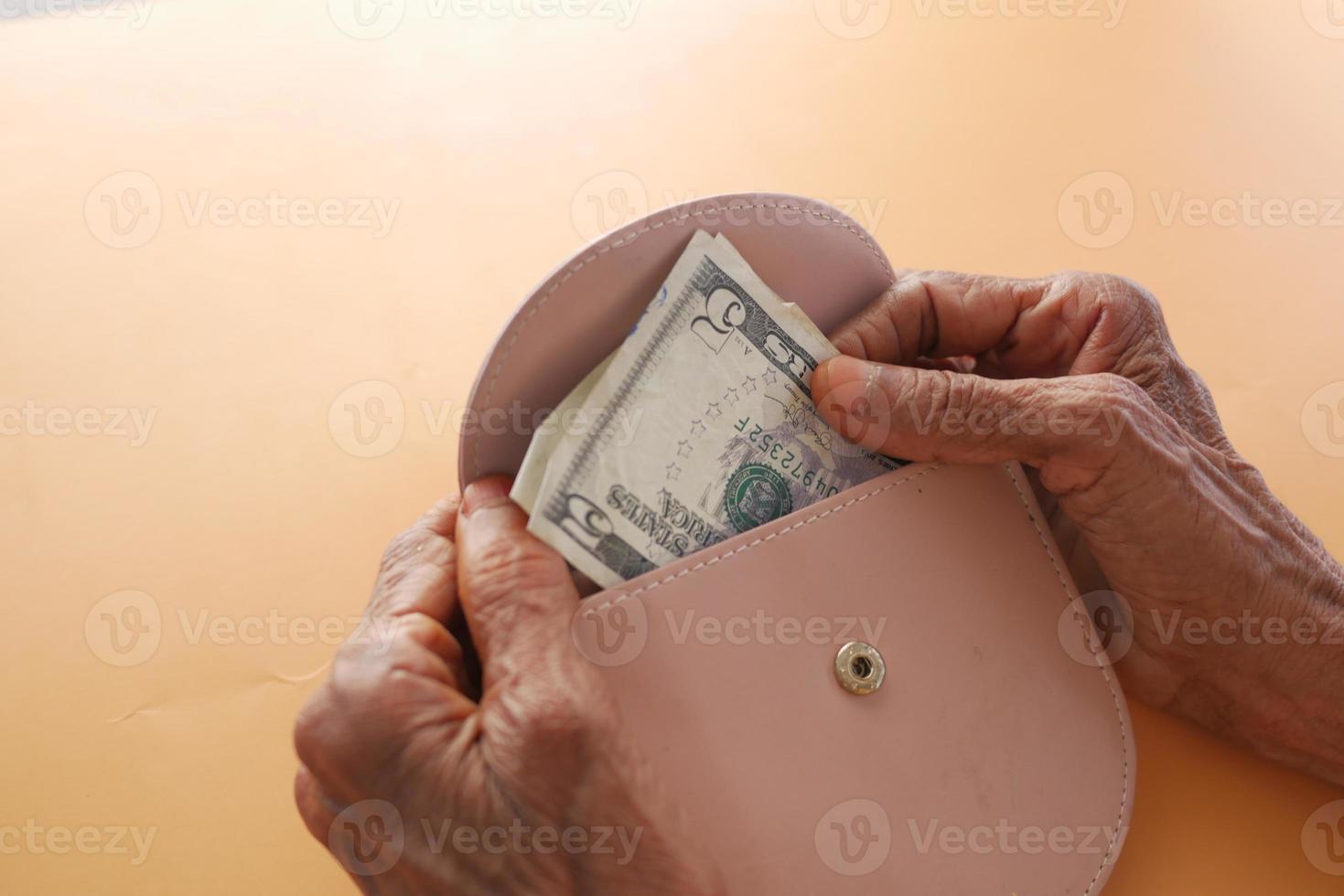 mulheres idosas economizando dinheiro na carteira foto