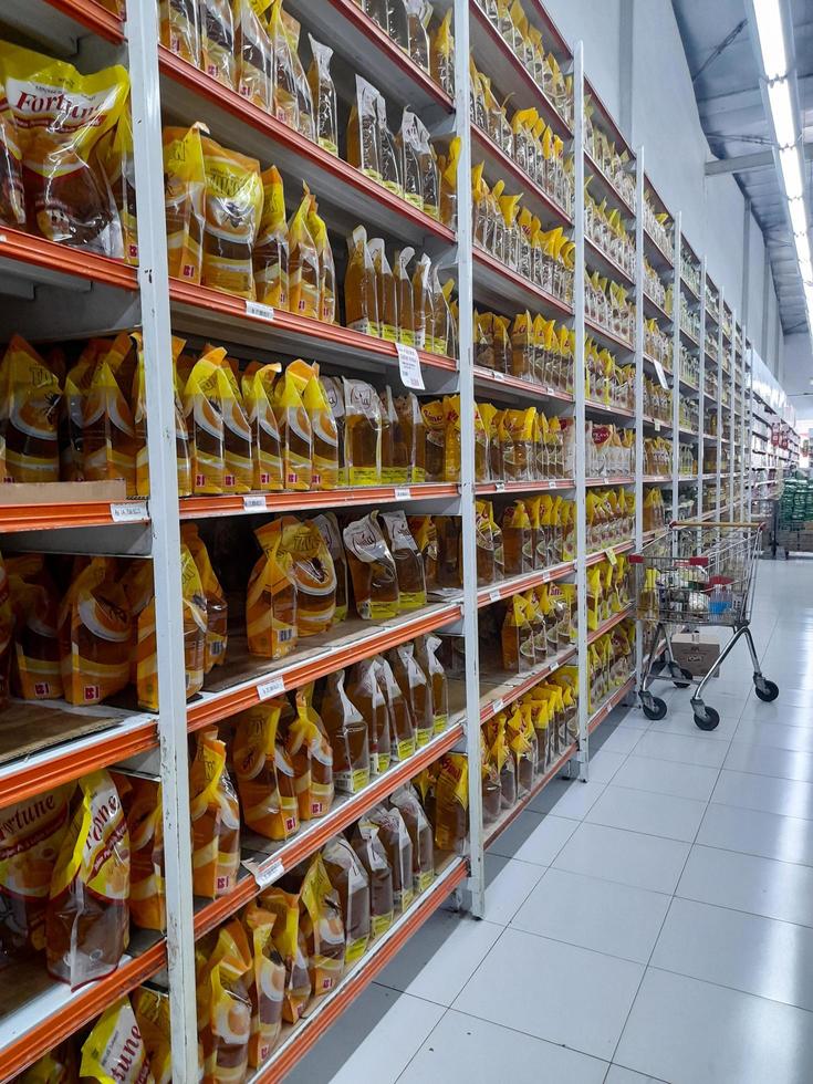 jombang, east java, indonésia, 2022 - as prateleiras dos supermercados contêm fileiras de óleo de cozinha embalado halal de várias marcas na indonésia. retrato de exibição de óleo de cozinha em shopping foto