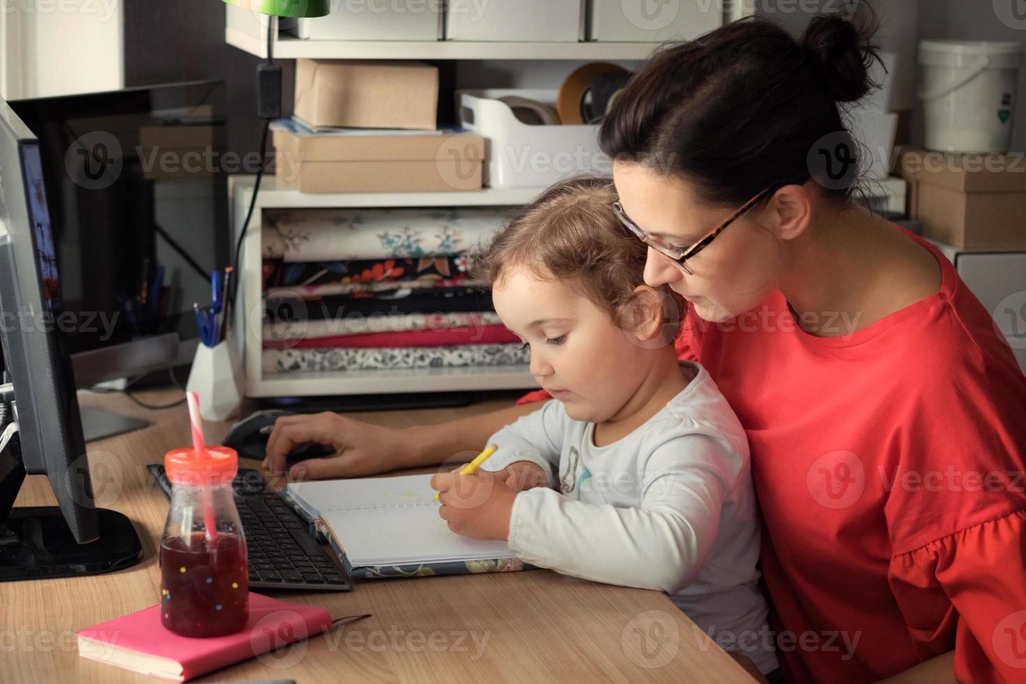 menina desenhando com a mãe em casa. foto