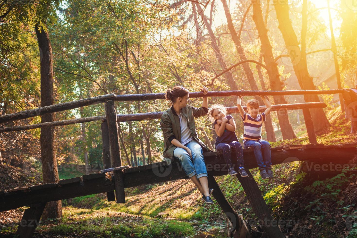 mãe com filhos desfrutando em dia ensolarado de outono na natureza. foto