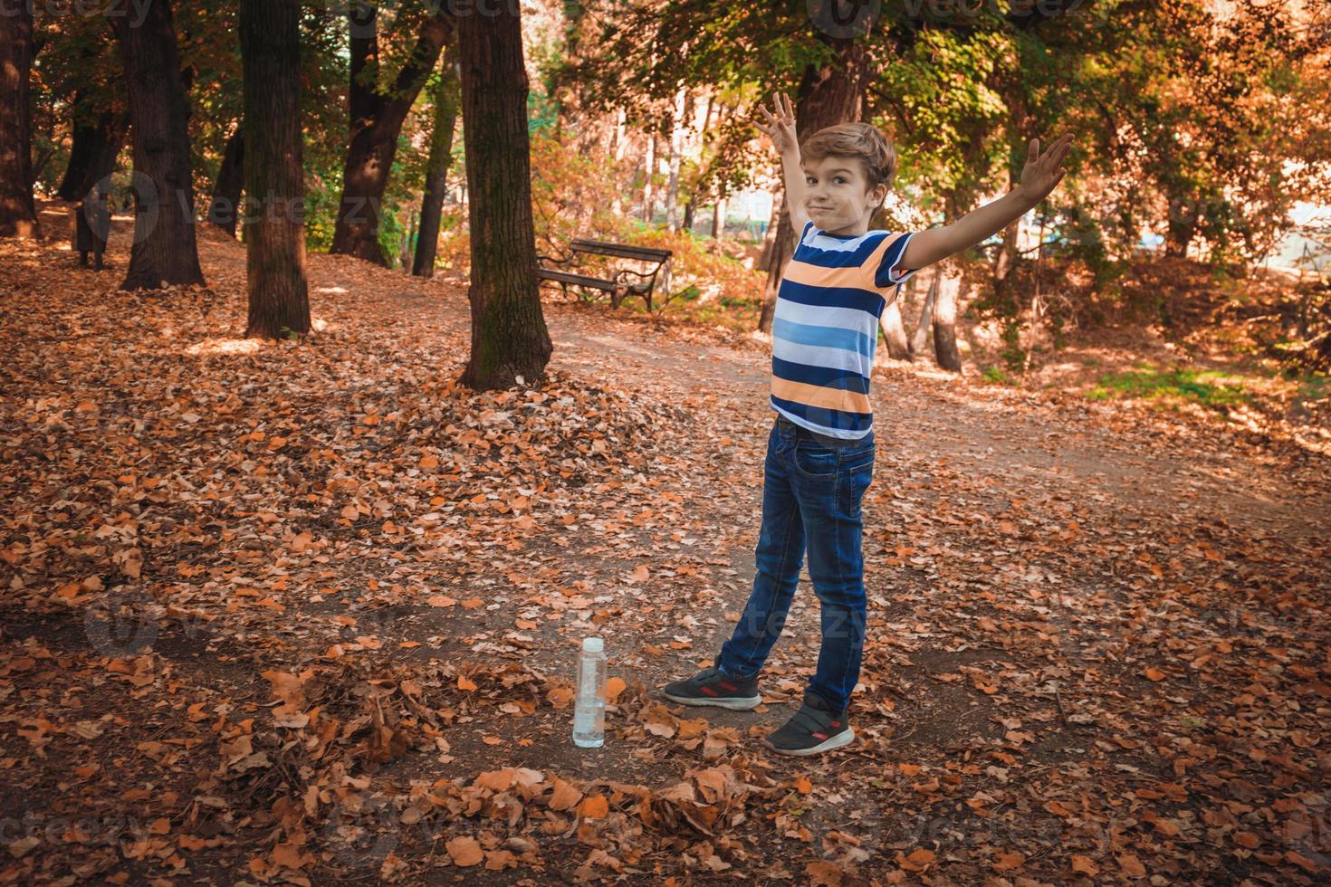 garotinho fazendo garrafa flip no parque. foto