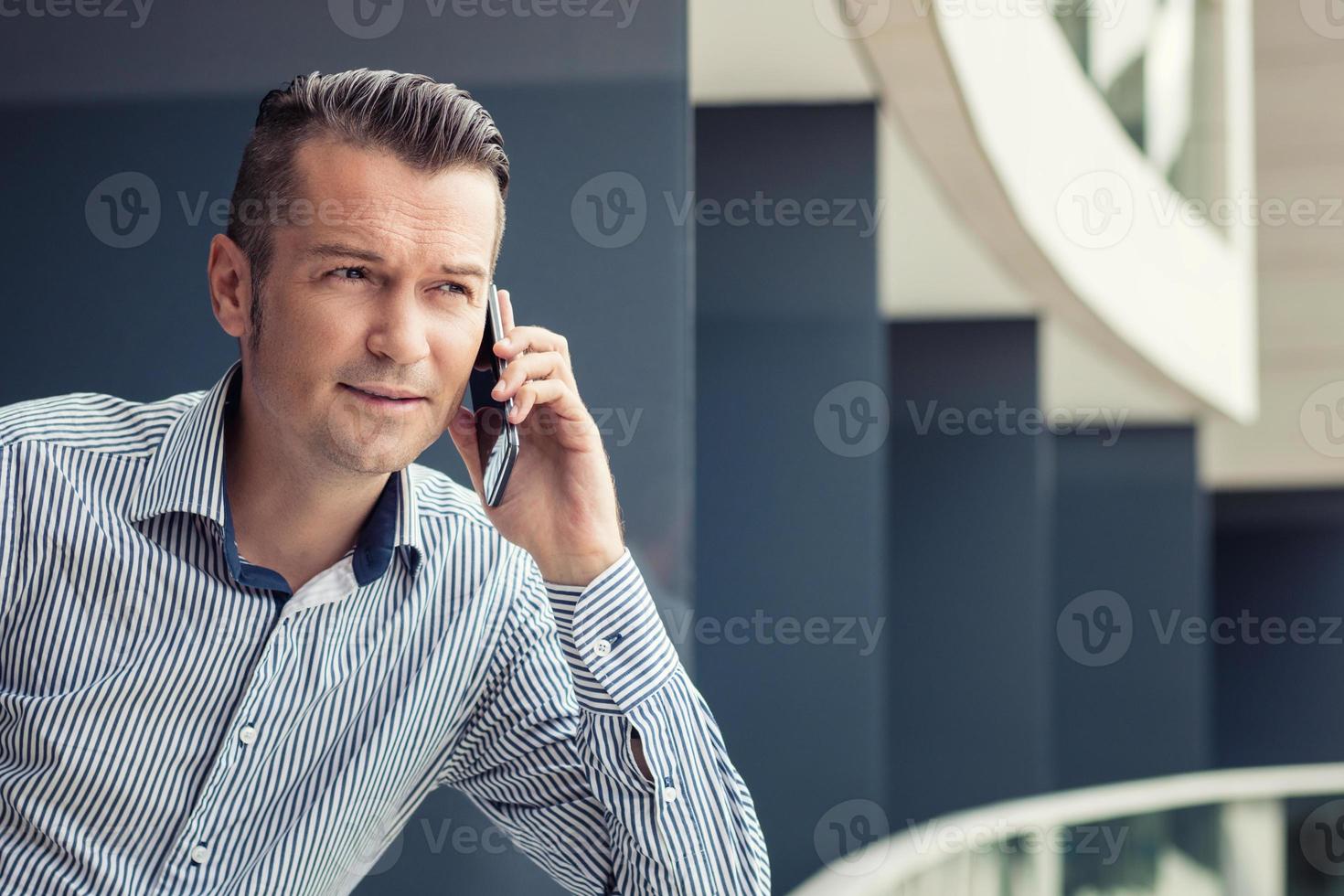 empresário falando ao telefone na varanda. foto