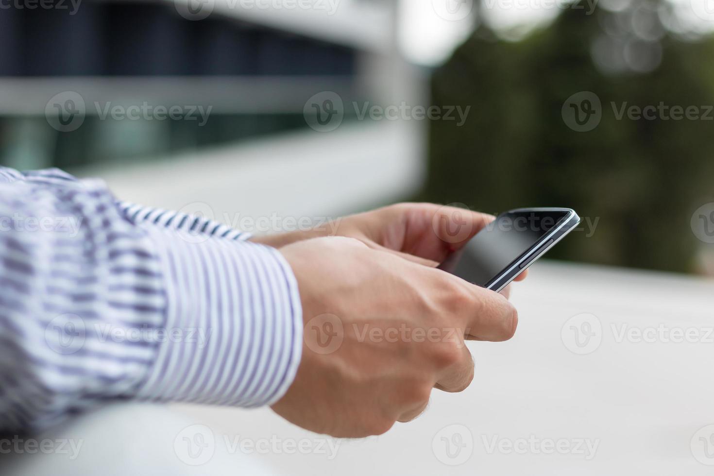 close-up de um empresário usando telefone celular. foto