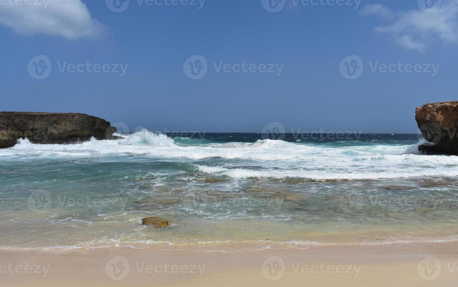 grandes ondas quebrando em terra nas areias brancas da pequena aruba foto
