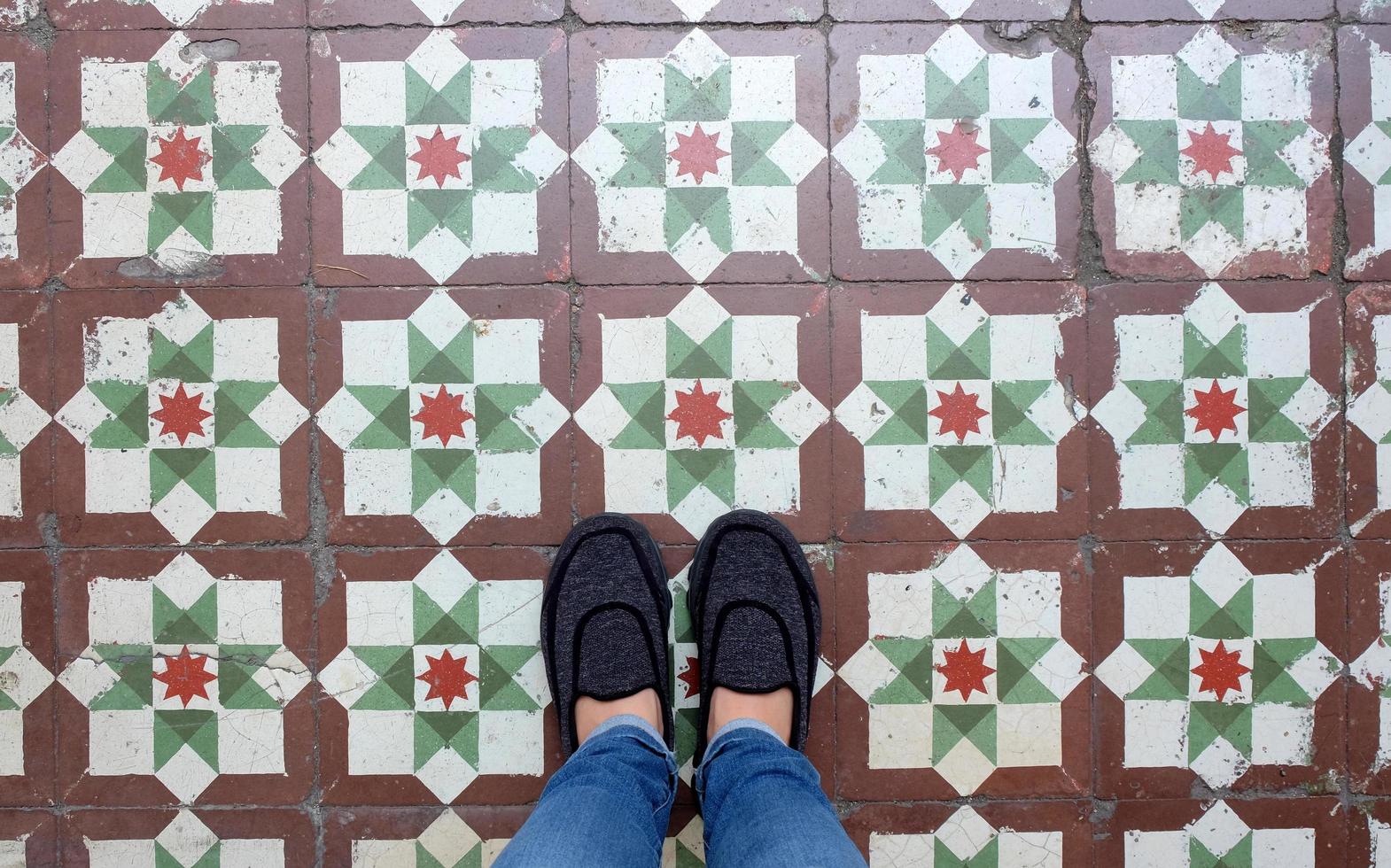 selfie de vista superior dos pés em sapatos de tênis no fundo do piso vintage sem costura com espaço de cópia foto