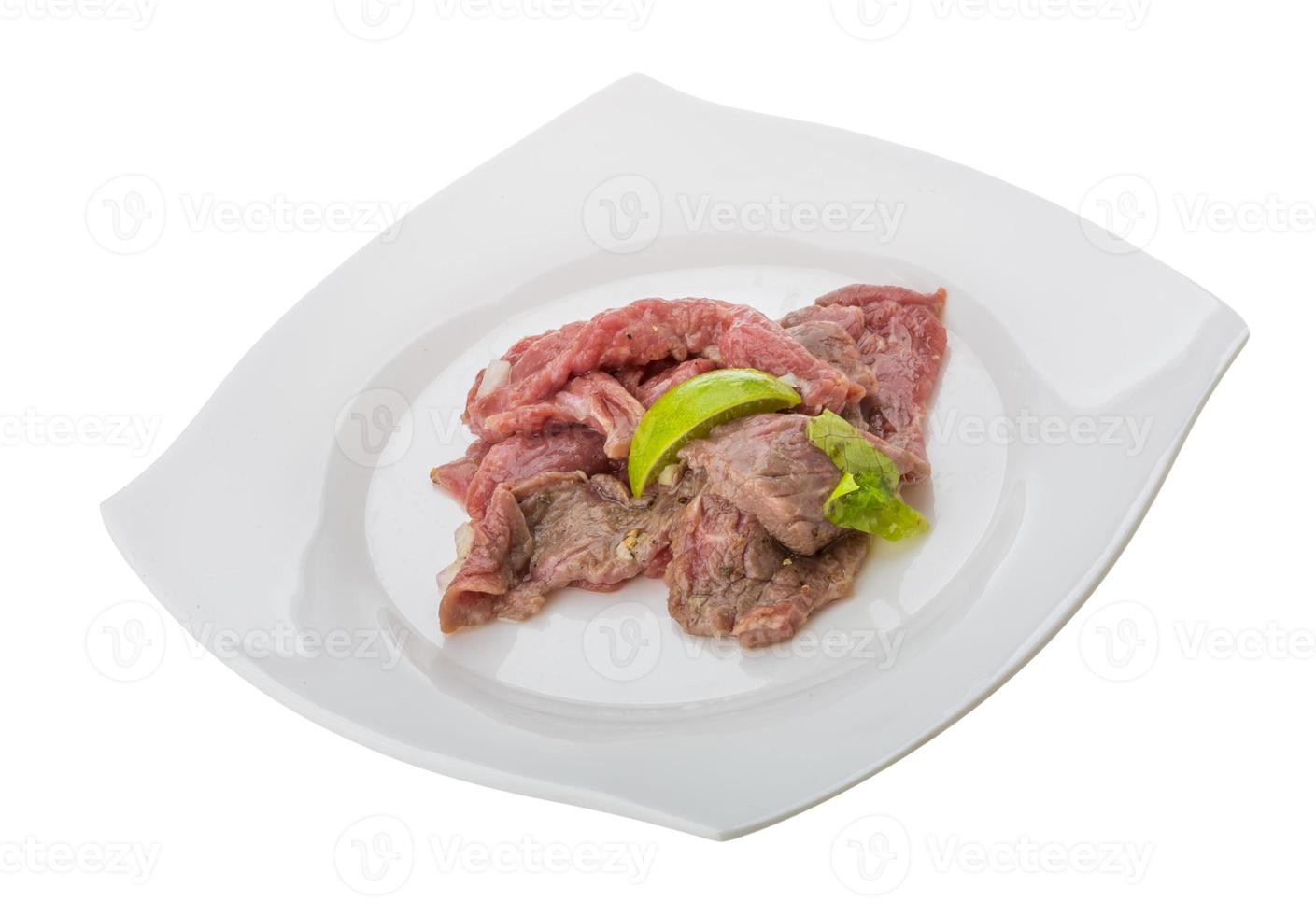 carpaccio de carne na chapa e fundo branco foto