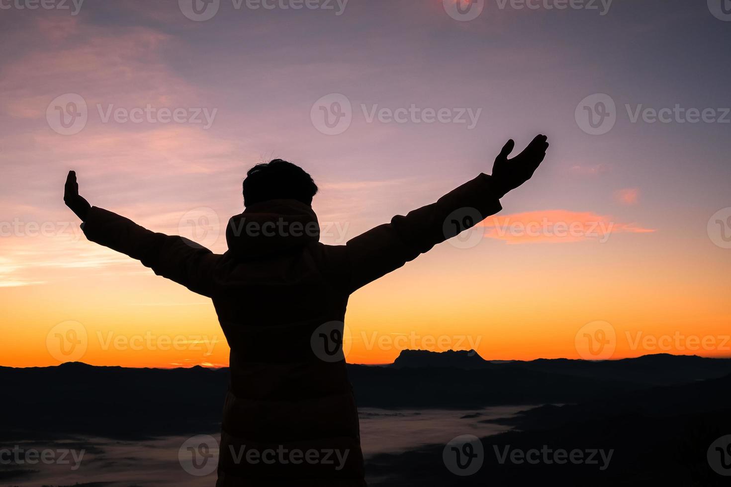 silhueta das mãos da pessoa humana abrem a palma para cima adoração no céu pôr do sol ou pôr do sol. homem adulto católico rezar e esperar na montanha. fundo do conceito de religião cristã. luta e vitória para deus foto