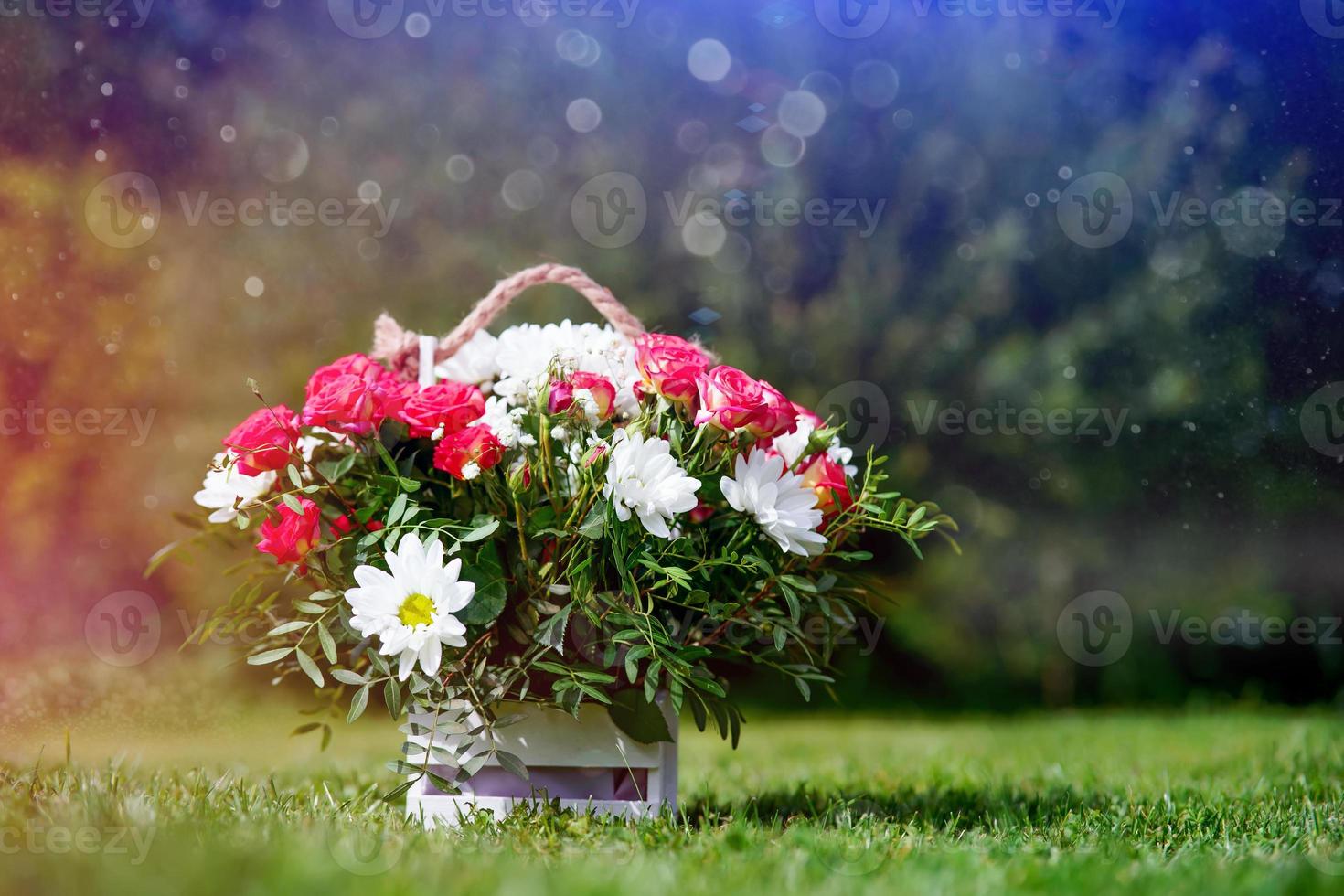 uma cesta de flores em um gramado verde foto