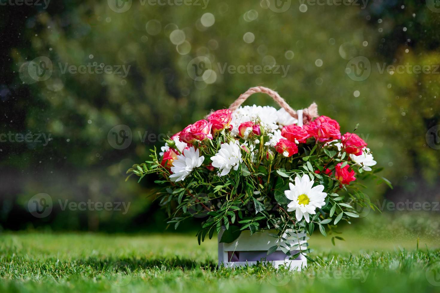 uma cesta de flores em um gramado verde foto